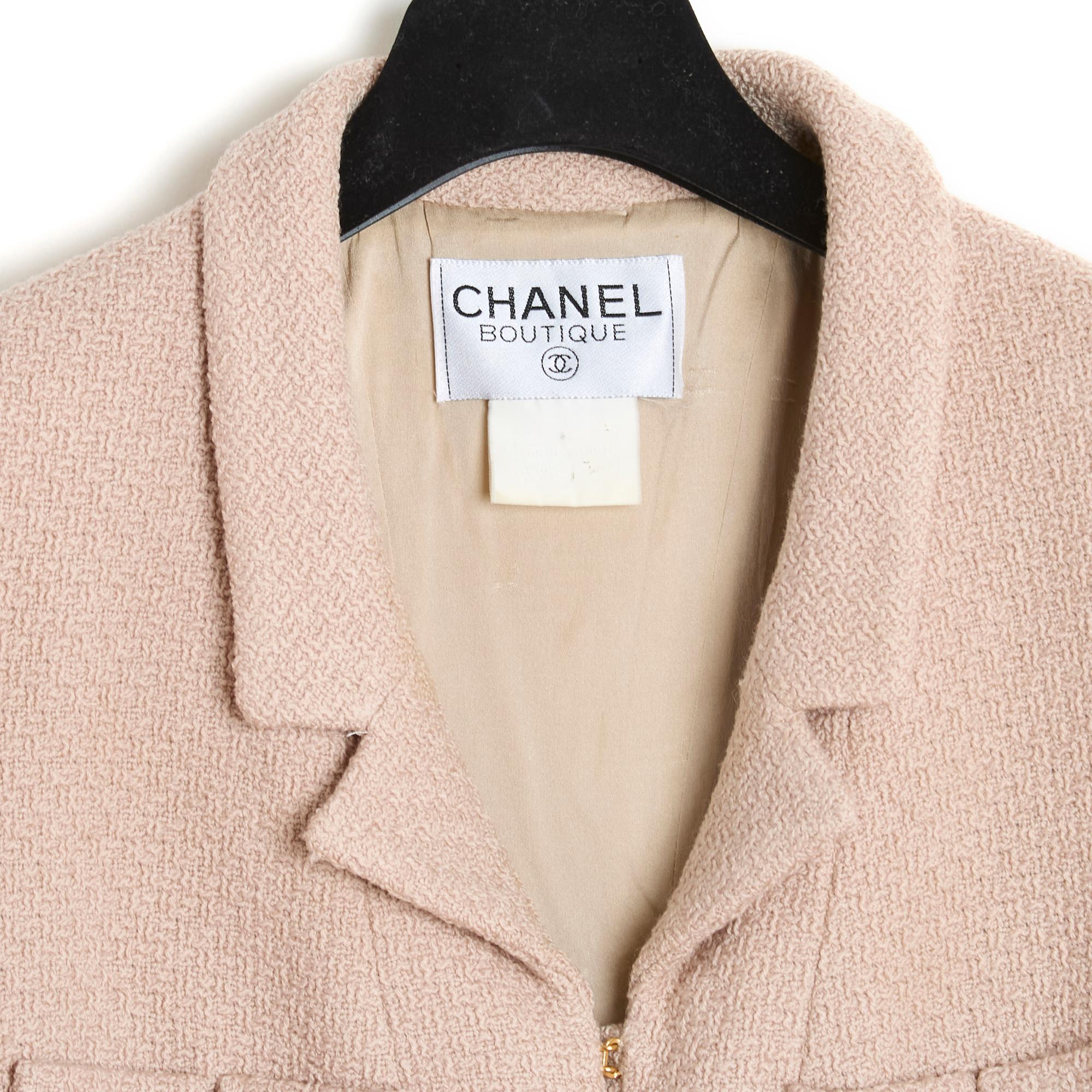 Veste Chanel de la collection Automne Hiver 1998 en laine rose-beige, petit col cranté fermé sur le devant par une série de 11 crochets en métal doré, 4 poches plaquées sur la poitrine et les hanches, manches longues fermées par 3 boutons logo CC,