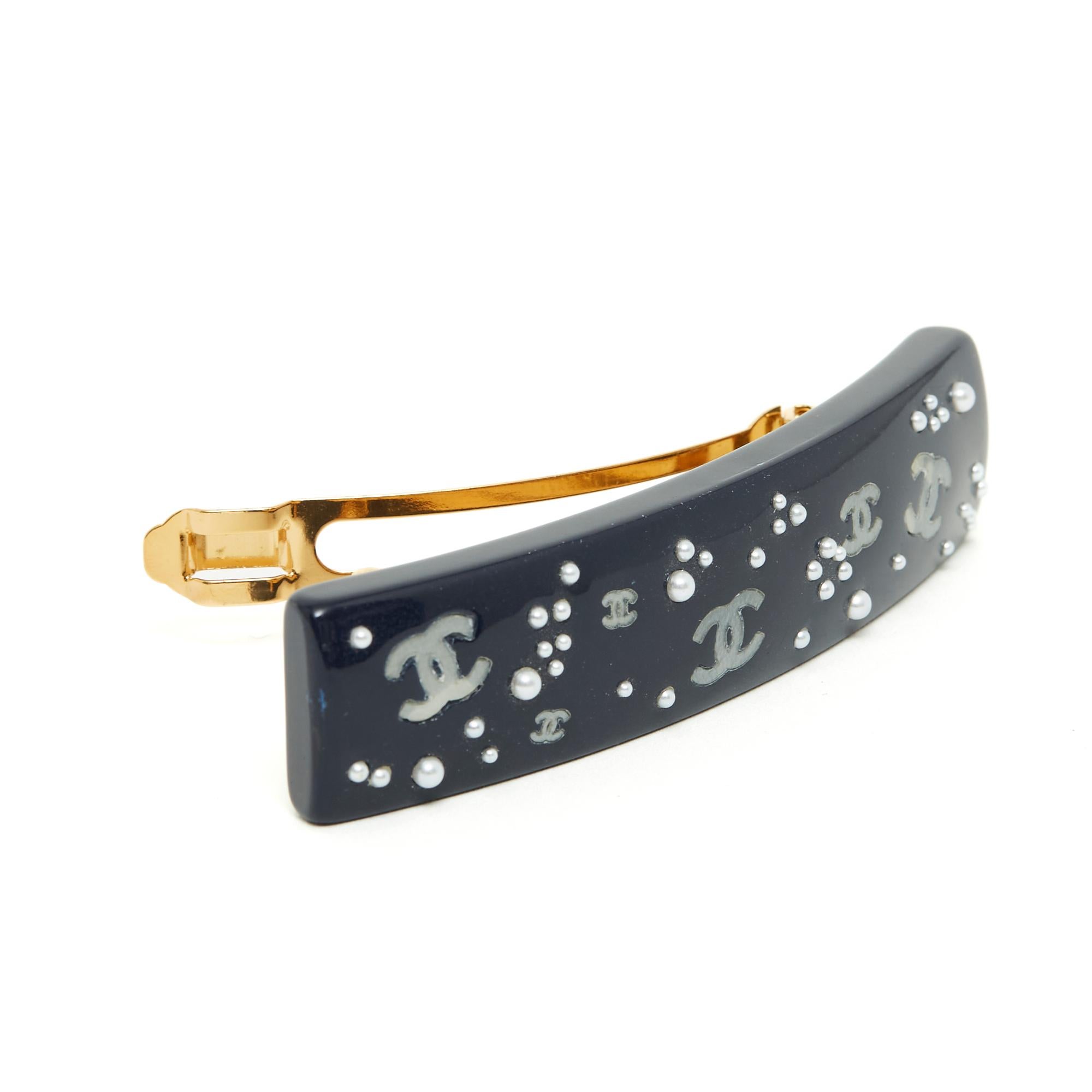 Chanel hairclip, FW2003 collection, XL format in midnight blue (very dark) resin inlaid with fancy pearls of different sizes and slightly iridescent gold CC. Length 10.2 cm x width 2.2 cm, dimensions of the metal bar 6.5 x 1 cm. The barrette is