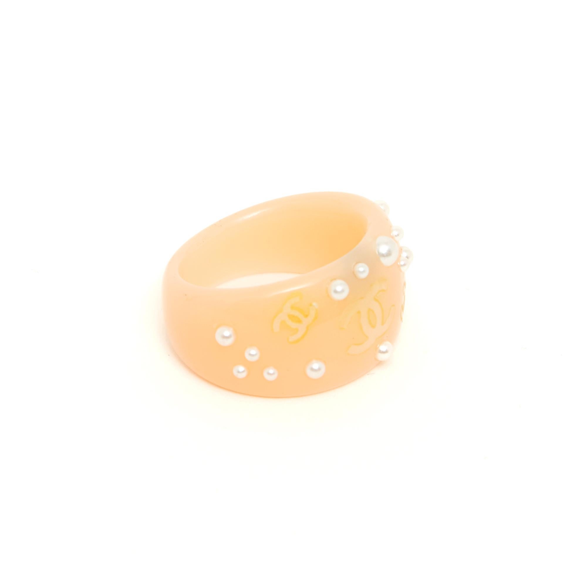 Chanel ring in pink resin inlaid with fancy pearls of different sizes and slightly iridescent gold CC. Size 53/54 ie US6.5, inner diameter 1.7 cm, top width 1.3 cm. The ring is vintage but nothing is missing and it is in very good condition.