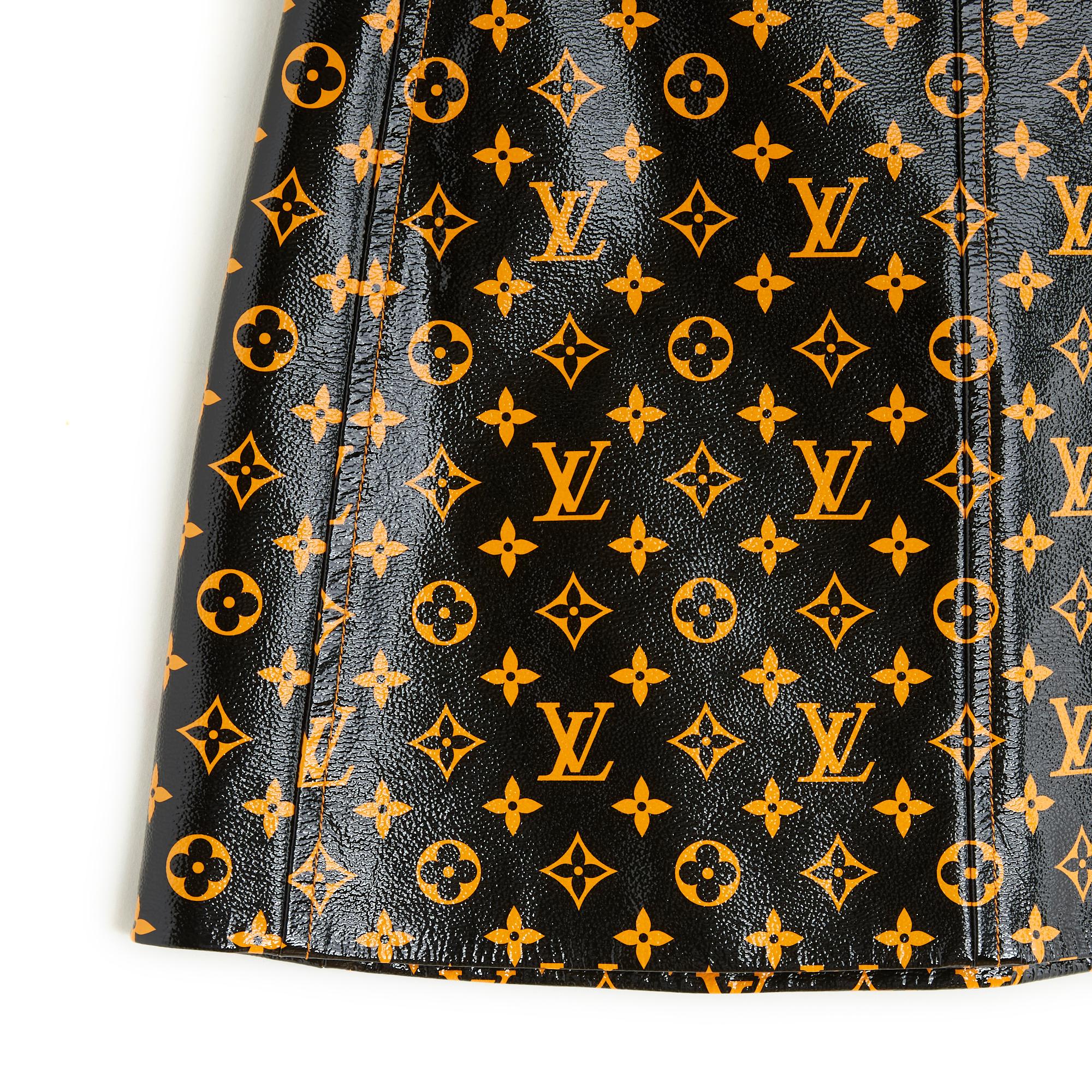 Short Louis Vuitton skirt in black patent leather with contrasting orange LV Initials pattern, orange-yellow satin canvas lining, fastening with a large logo zip at the back. Size 38FR: waist 38 cm, length 43 cm. The skirt comes from private sales,