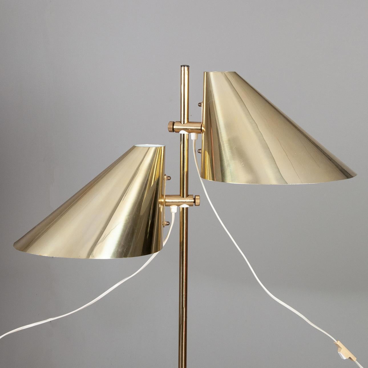 Chic and elegant, this floor lamp comes with a height adjustment system for the 2 lamps which allows aesthetic and refined lighting. Modern lamp produced in Sweden by Markaryd in the 1960s. Its brass structure gives it a lot of charm. H 152 cm