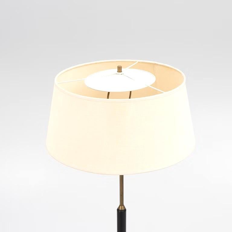 Très élégant lampadaire du fabricant de lampes suédois Bergboms avec sa base tripode, datant des années 1950. L'assemblage des matériaux avec la tige en bois noir, la structure et l'anneau en laiton lui confère son esthétique originale et