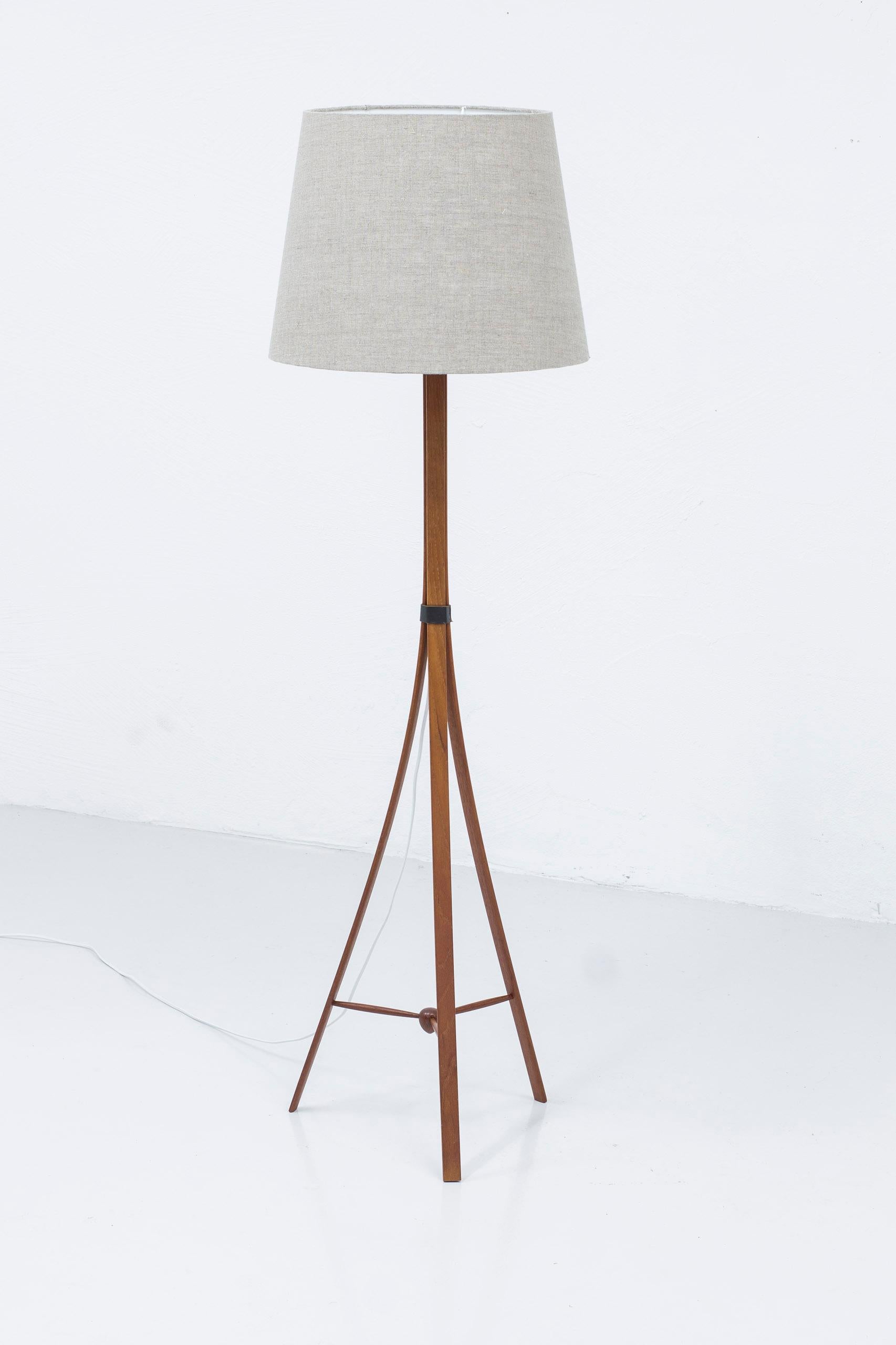Floor lamp model G-35 designed by Alf Svensson. Produced in Sweden by Bergboms during the 1950s. Rare version made from steam bent solid teak, black original leather straps and brass lamp holder. Shade in grey linen fabric. Bakelite turning light