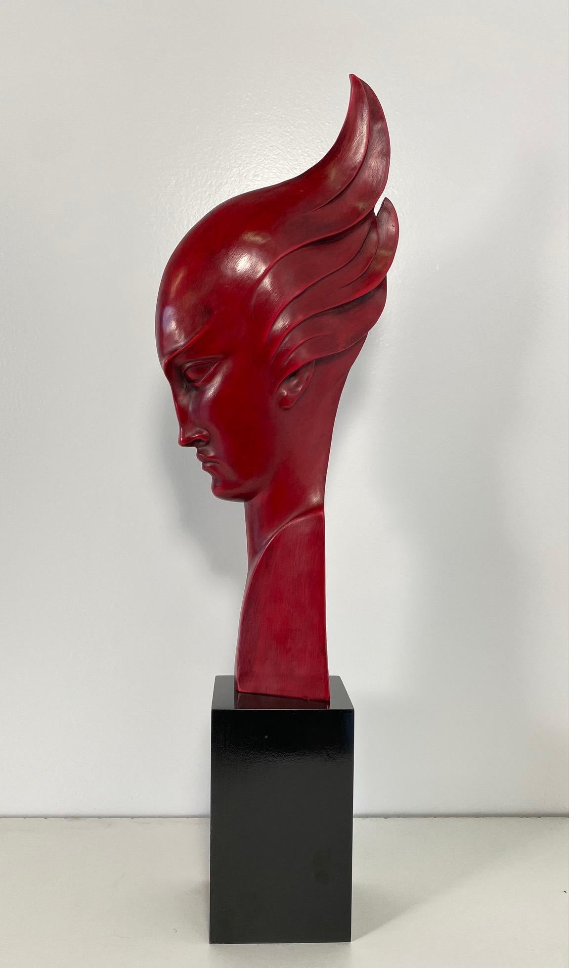 This Art Deco sculpture was produced in Italy and more precisely in Milan, by Guido Cacciapuoti in the 1930s. 

The base is in ebonized wood and the sculpture, a typical Art Deco stylized woman profile face, is in in red porcelain stoneware.

On
