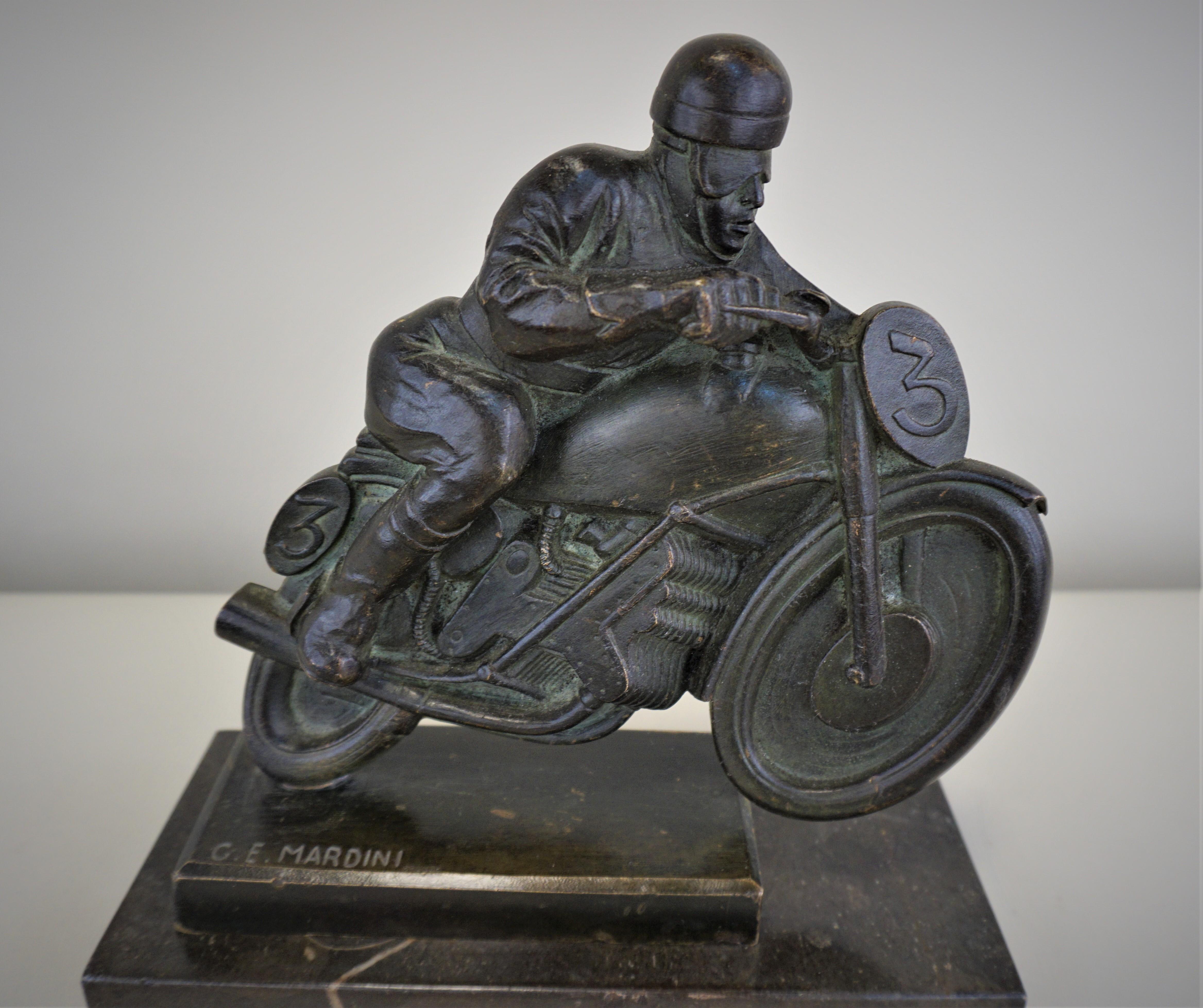 E. Mardini 1930's dark/black with touch of green, bronze riding motorcycle on back texture marble base.

