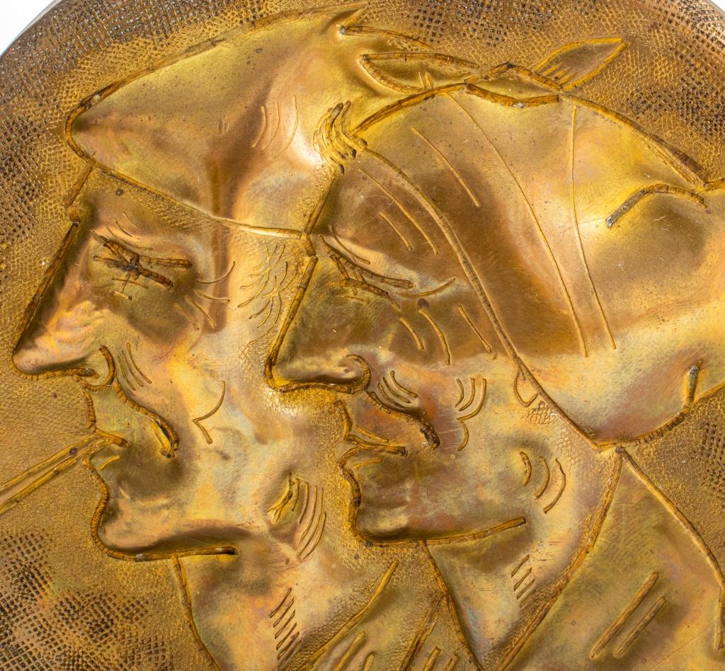 G. Lhoste hammered brass gong depicting a old couple signed, raised on a Art Deco cast-iron base.

Dimensions: 7.5