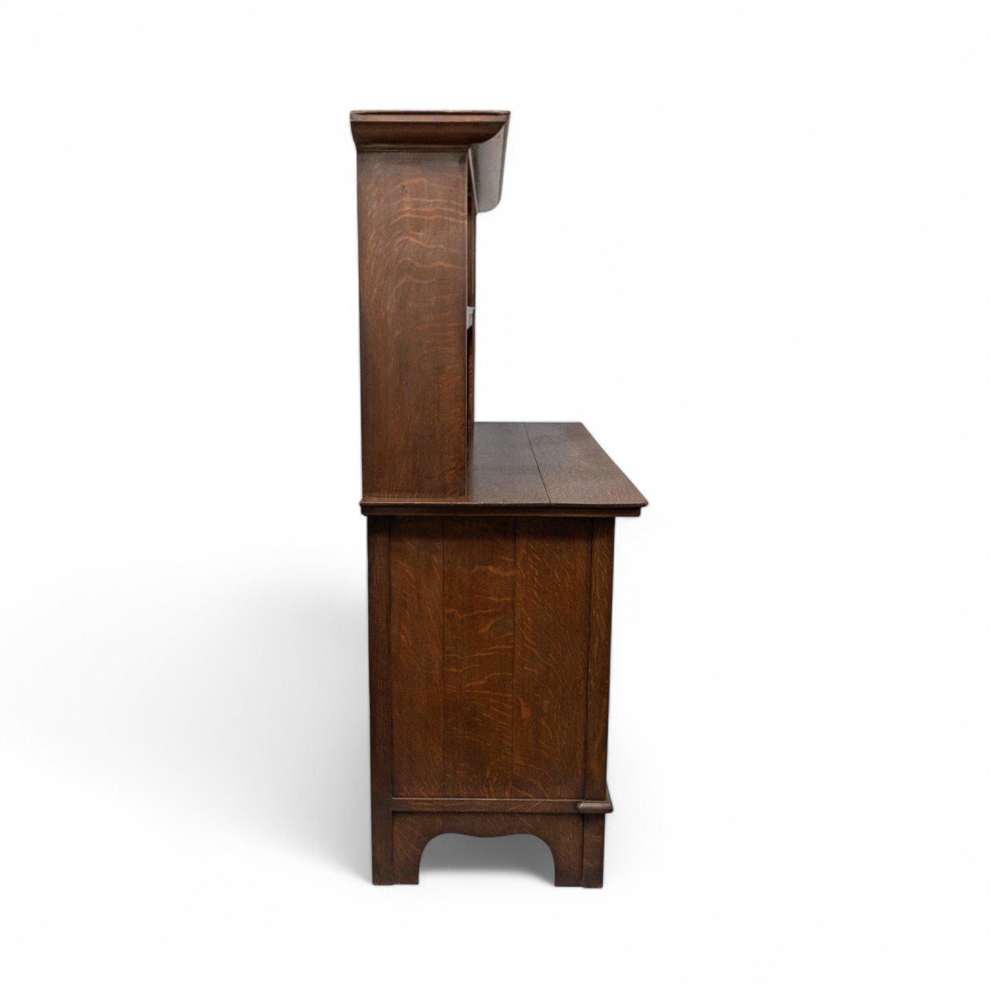 G. M. Ellwood attribuito a M. I.
Credenza in rovere in stile Arts and Crafts Glasgow realizzata da Bath Cabinet Makers, con pannello in vetro colorato nell'armadio in alto a destra, dettagli floreali stilizzati intarsiati con legno di tulipano,
