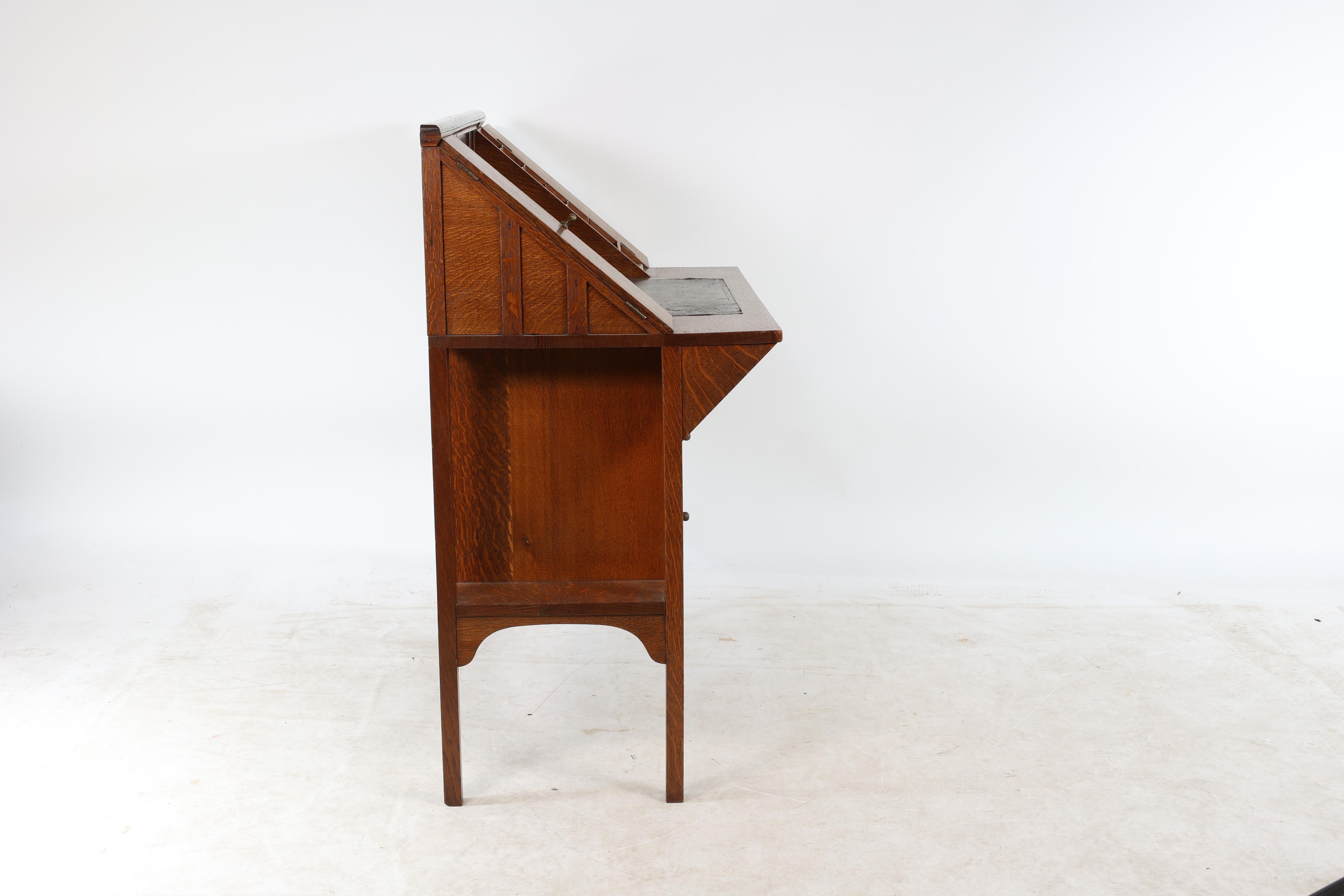 English G M Ellwood for J S Henry. An Arts & Crafts oak writing desk For Sale