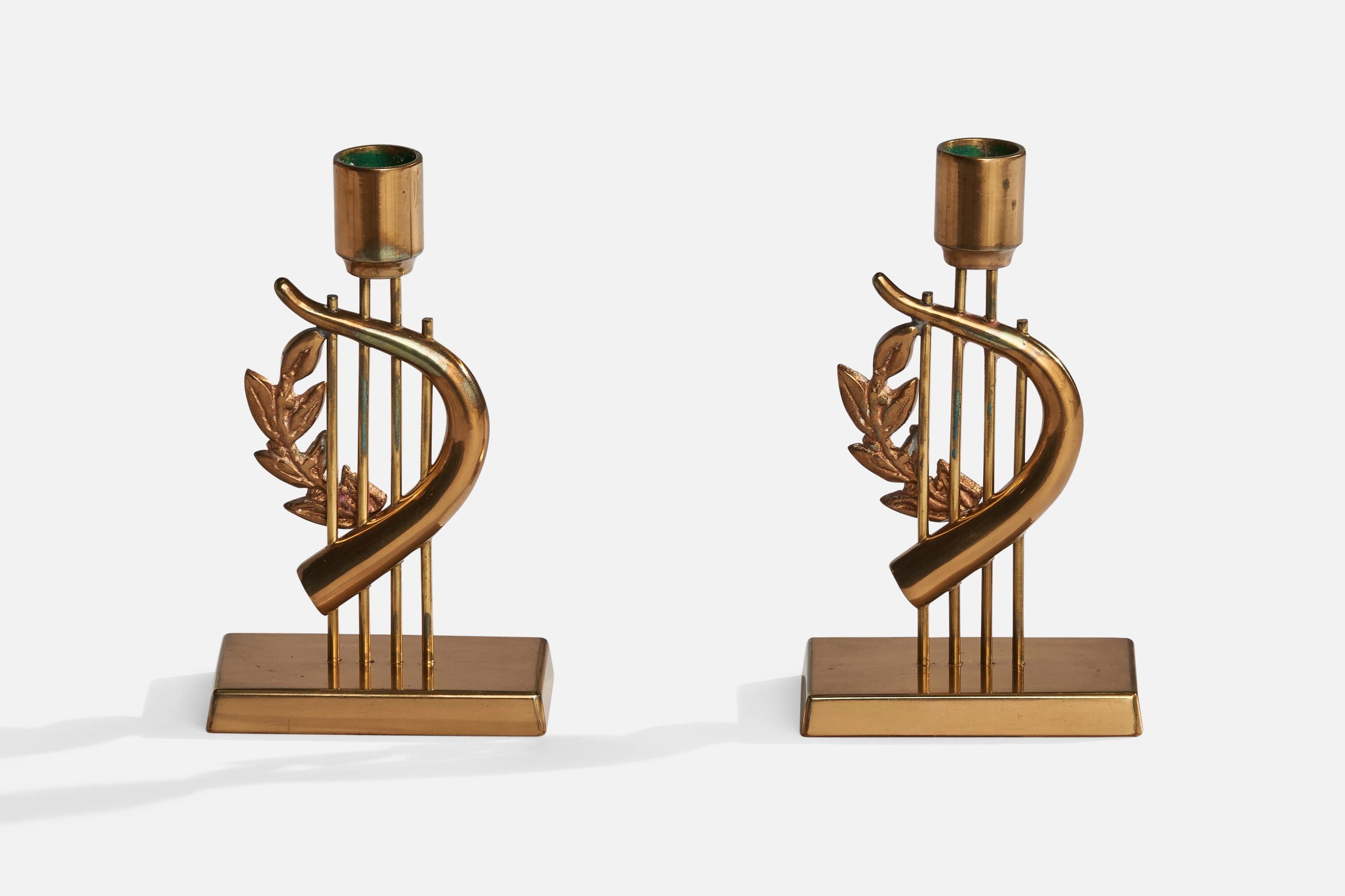 A pair of brass candlesticks designed and produced by G. Magnusson Design, Sweden, 1985.

Holds 0.7” diameter candles