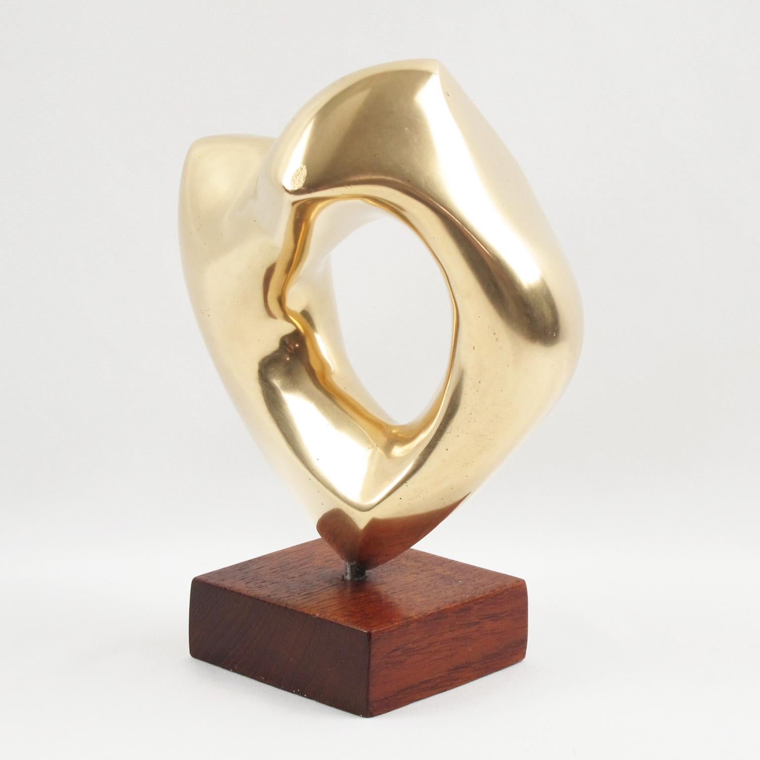 Lovely abstract bronze sculpture by G. Morleghem, Belgium, circa 1950s. Featuring an interesting organic free-form shape with polished finish. Geometric square base in mahogany. Engraved signature on side. 
Measurements: 3.94 in. wide (10 cm) x