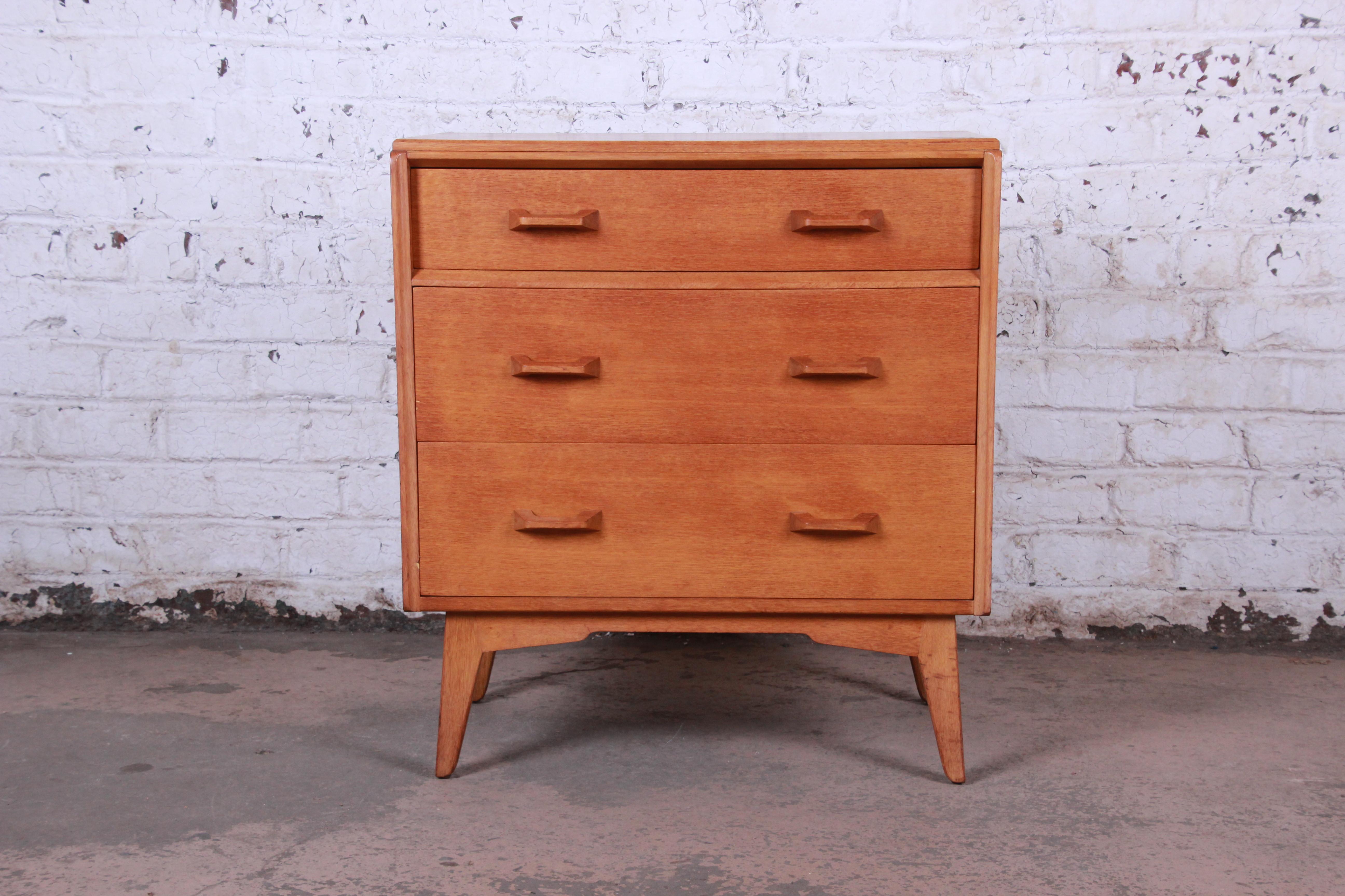 A gorgeous Mid-Century Modern light oak bachelor chest by E Gomme G-Plan. This chest of three drawers is finished in star-fleck figured oak with solid oak edges, legs and handles. It offers good storage, with three deep dovetailed drawers. The