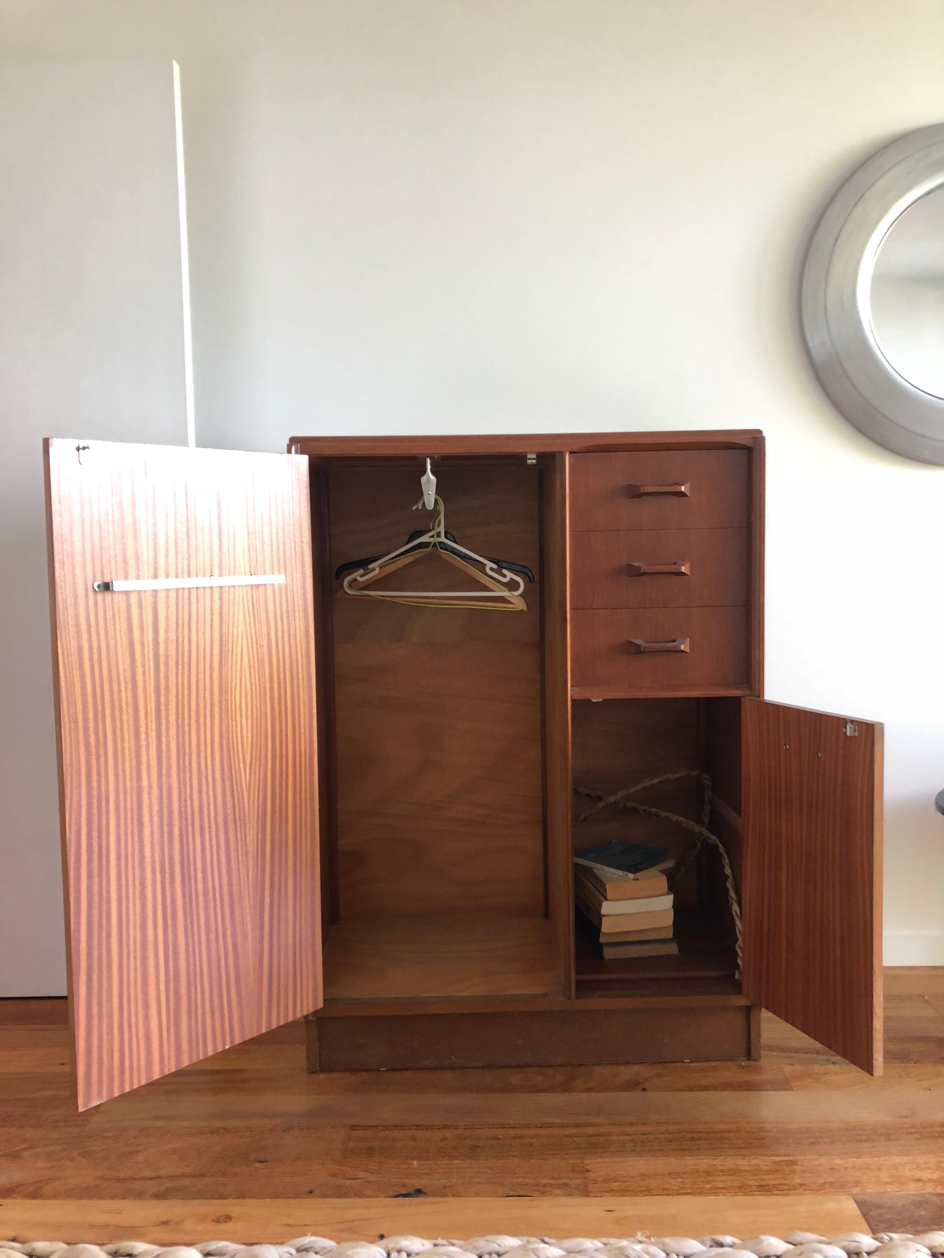 G Plan teak gents robe
E Gomme gold embossed stamp to door interior.
Early G plan stamp used 1952 to 1965
Geometric form handles and rounded corners reflecting iconic midcentury lines
Hanging space, drawers and storage compartment.