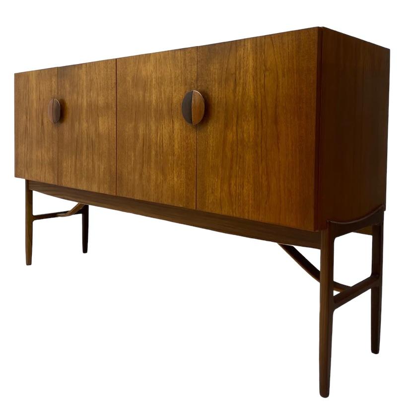 A superb midcentury sideboard designed by Kofod Larsen for G Plan/ E Gomme model 4060. This magnificent sideboard was designed in the 60s with much Danish influence & sits handsomely on elegant legs. The sideboard is in teak with its rich colours &