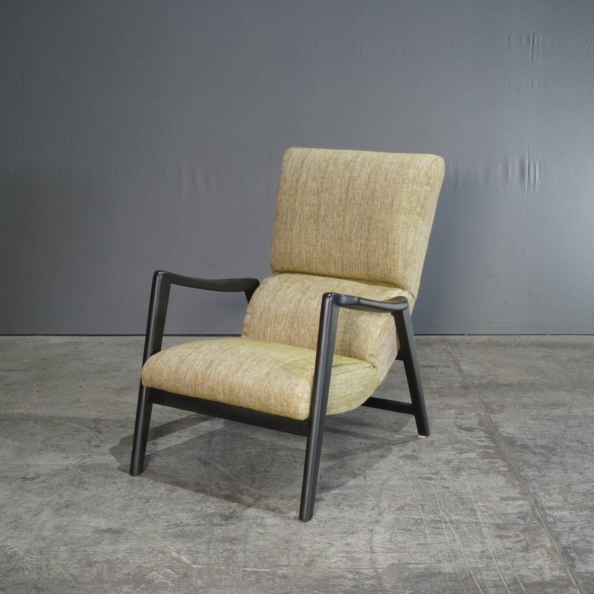 The G Plan E Gomme Siesta Armchair, newly upholstered in a soft, olive-green fabric, is an iconic mid-century design by VB Wilkins. Its distinctive frame, crafted from solid wood, showcases sleek, angled arms that contrast beautifully with the