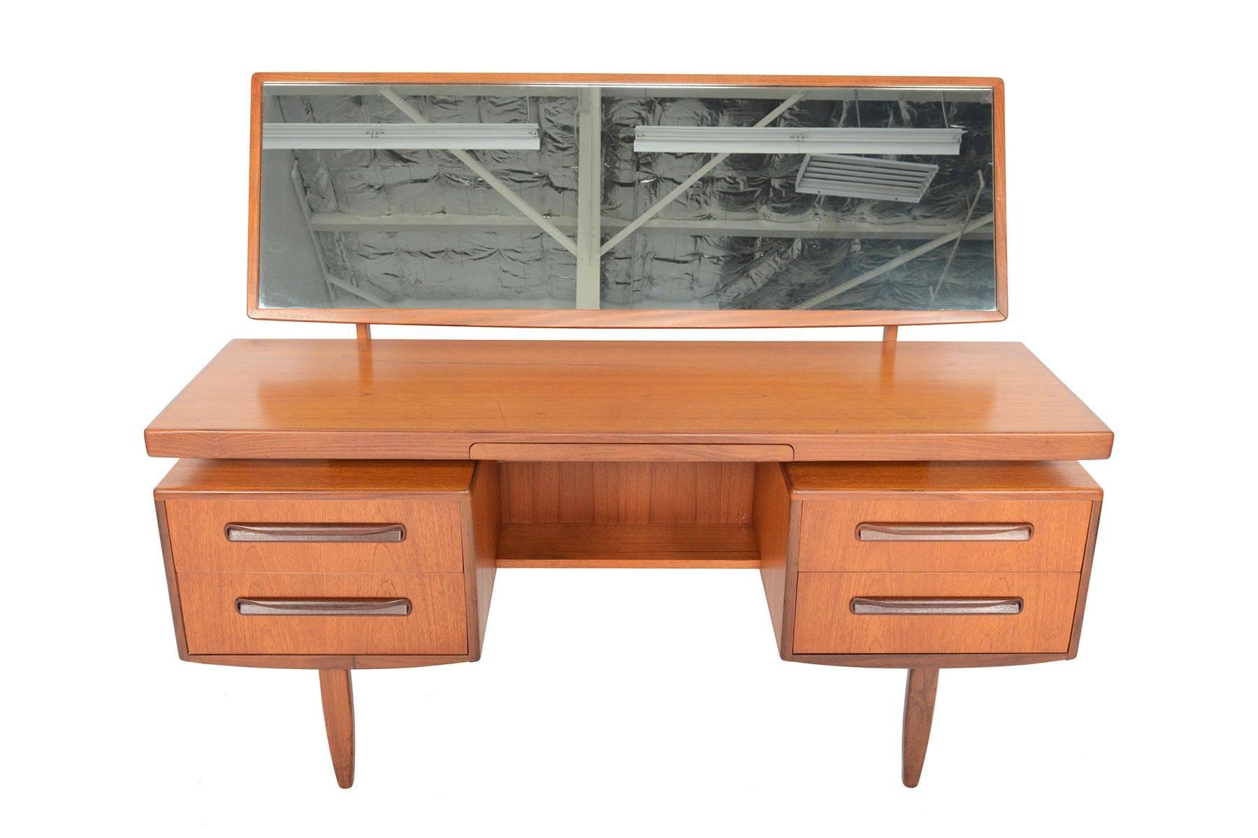 This English Mid-Century Modern G Plan Fresco floating top teak vanity desk was designed by Victor Wilkins in the 1960s. Mirror articulates and easily detaches for storage. Middle drawer pulls out to reveal a deep, velvet lined jewelry drawer. Two