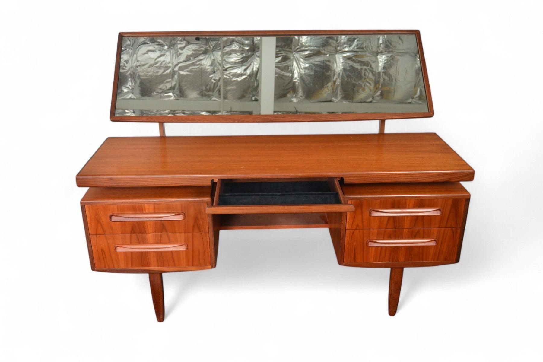 Origen: Inglaterra
Diseñador: Victor B. Wilkins
Fabricante: G Plan
Época: 1966
Materiales: Teca, Afromosia
Medidas: 59″ de ancho x 18″ de fondo x 28″ de alto (hasta la parte superior del escritorio), 47,5