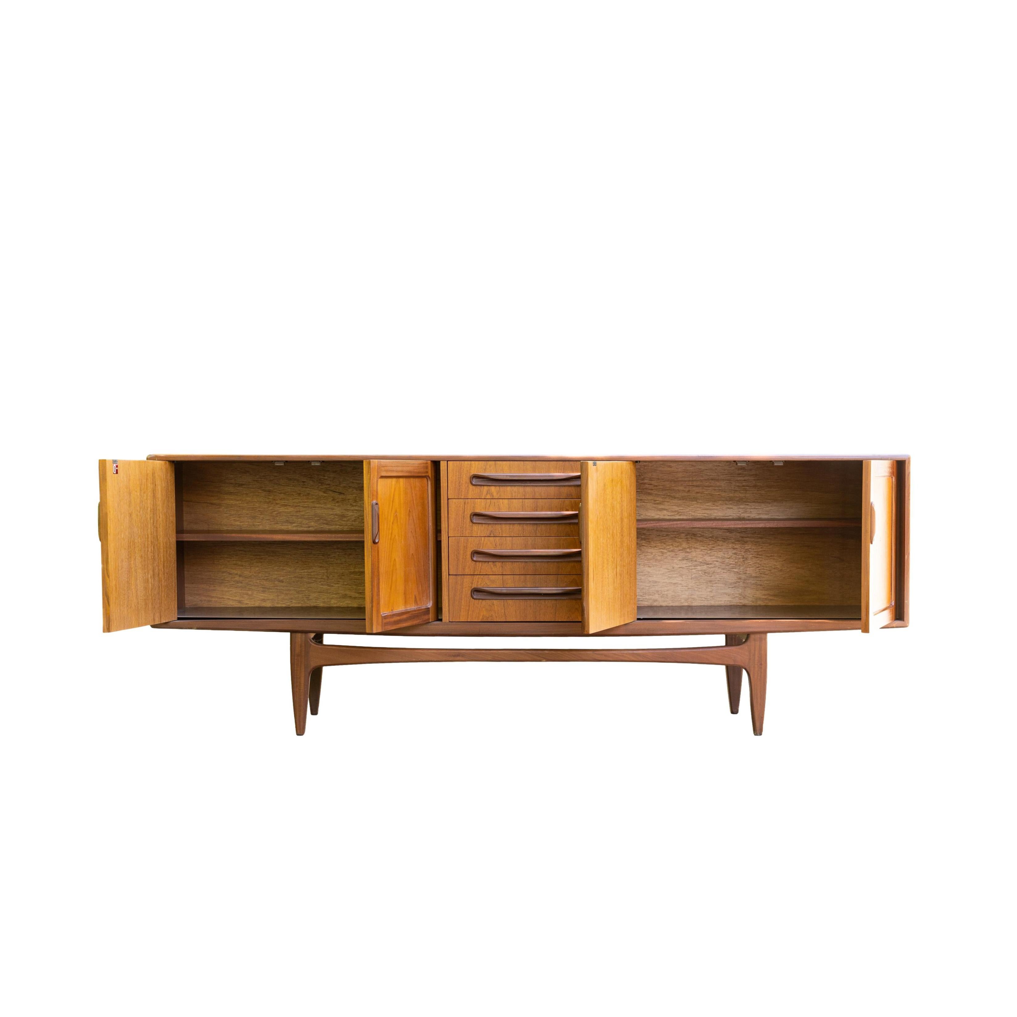 Mid-Century Modern teak sideboard designed by Victor Wilkins for G-Plan, in solid teak and afrormosia teak on ‘Floating Base,’ with extensively fitted interior. Built to the highest standards, the piece exudes quality, beauty and style. Highly