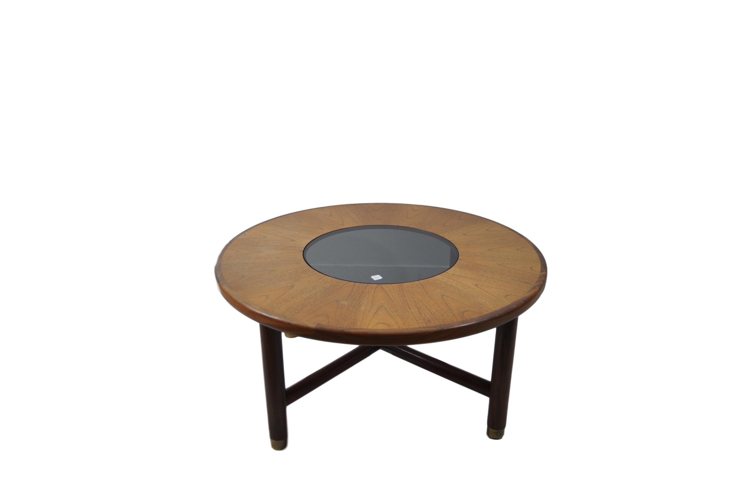 Rare round teak and smoked glass coffee table by G-Plan, circa 1960. This particular table is of the lighter teak variant and some minimal wear around the brass plate detailing.