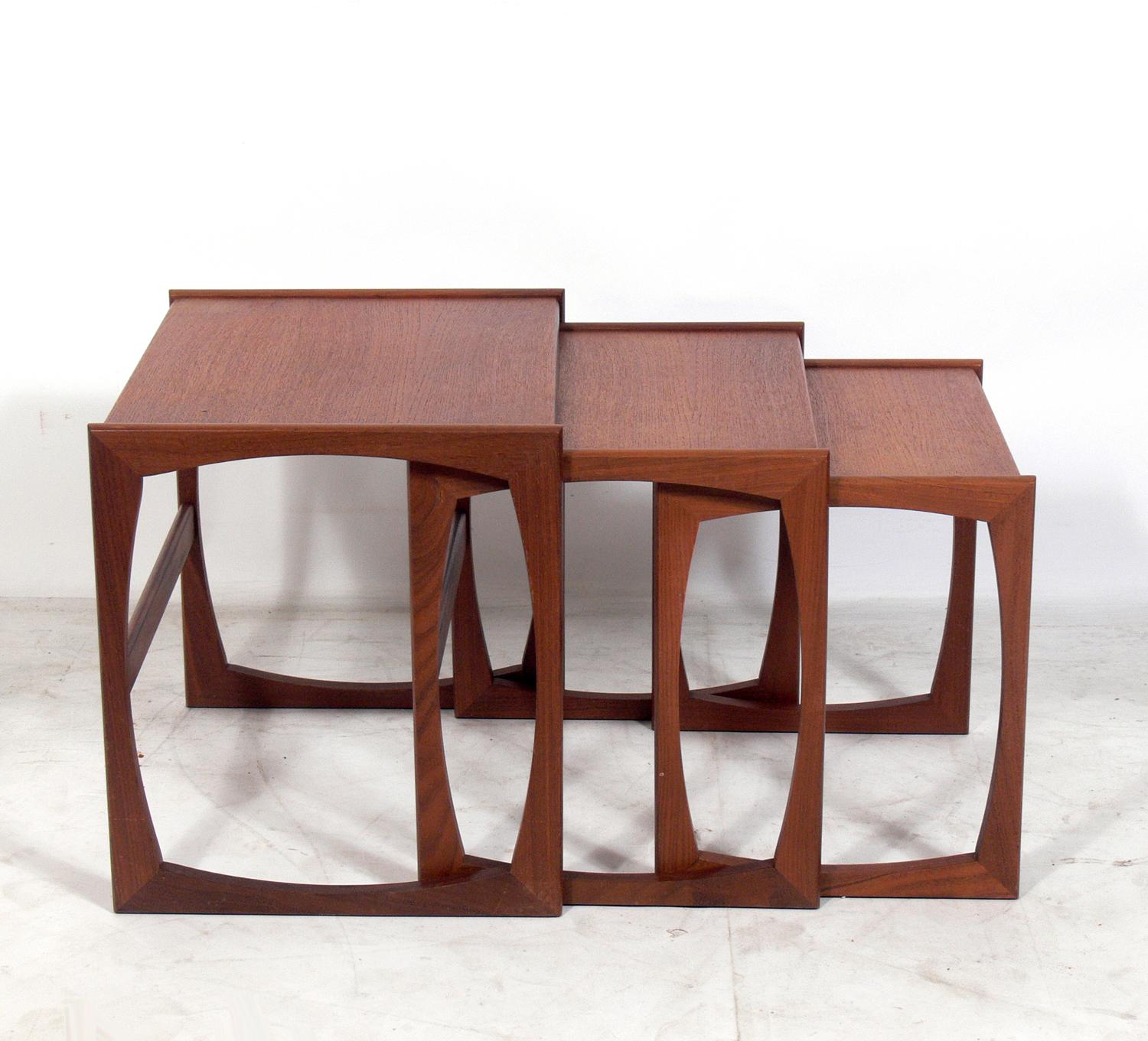 Set of three Mid-Century Modern nesting tables, designed for G Plan, England, circa 1960s. While they certainly have a Danish modern style, they were designed in England for G Plan. The largest table measures 19