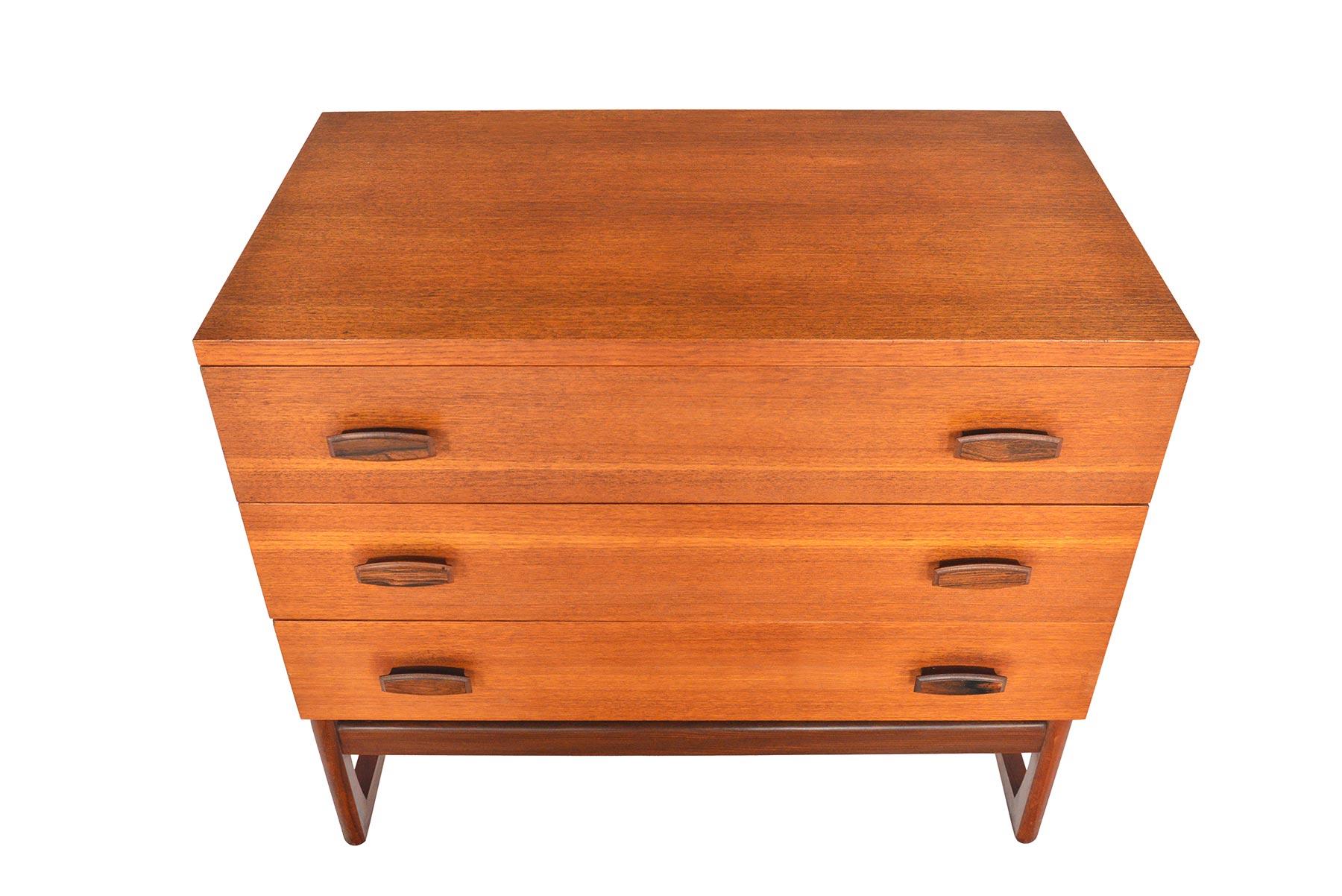This English modern G Plan Quadrille range three drawer gentleman's chest was designed by R. Bennett in 1965. This fantastic piece features three deep drawers adorned with carved afrormosia pulls. Case stands on the Quadrille range's signature