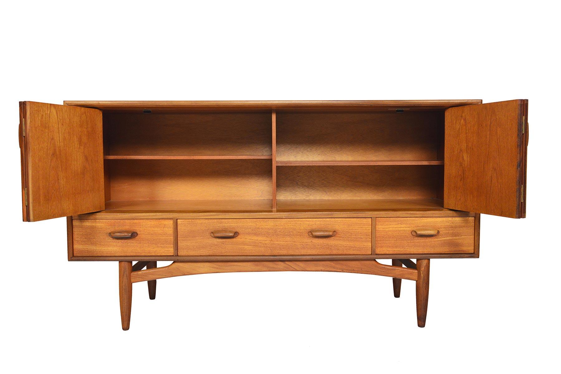 This gorgeous Mid-Century Modern teak credenza from G Plan’s Scandinavian Range was designed by Victor Wilkins in the 1960s. This exceptional piece features rolled solid teak handles and a massive amount of storage. The cabinet features two