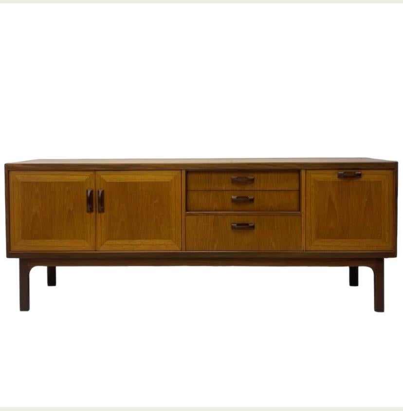 A beautifully crafted 1970s sideboard by British manufacturer G Plan. The sideboard features contrasting solid teak doors & handles. The sideboard has great storage with three good sized drawers, one with cutlery dividers, one large cupboard with a