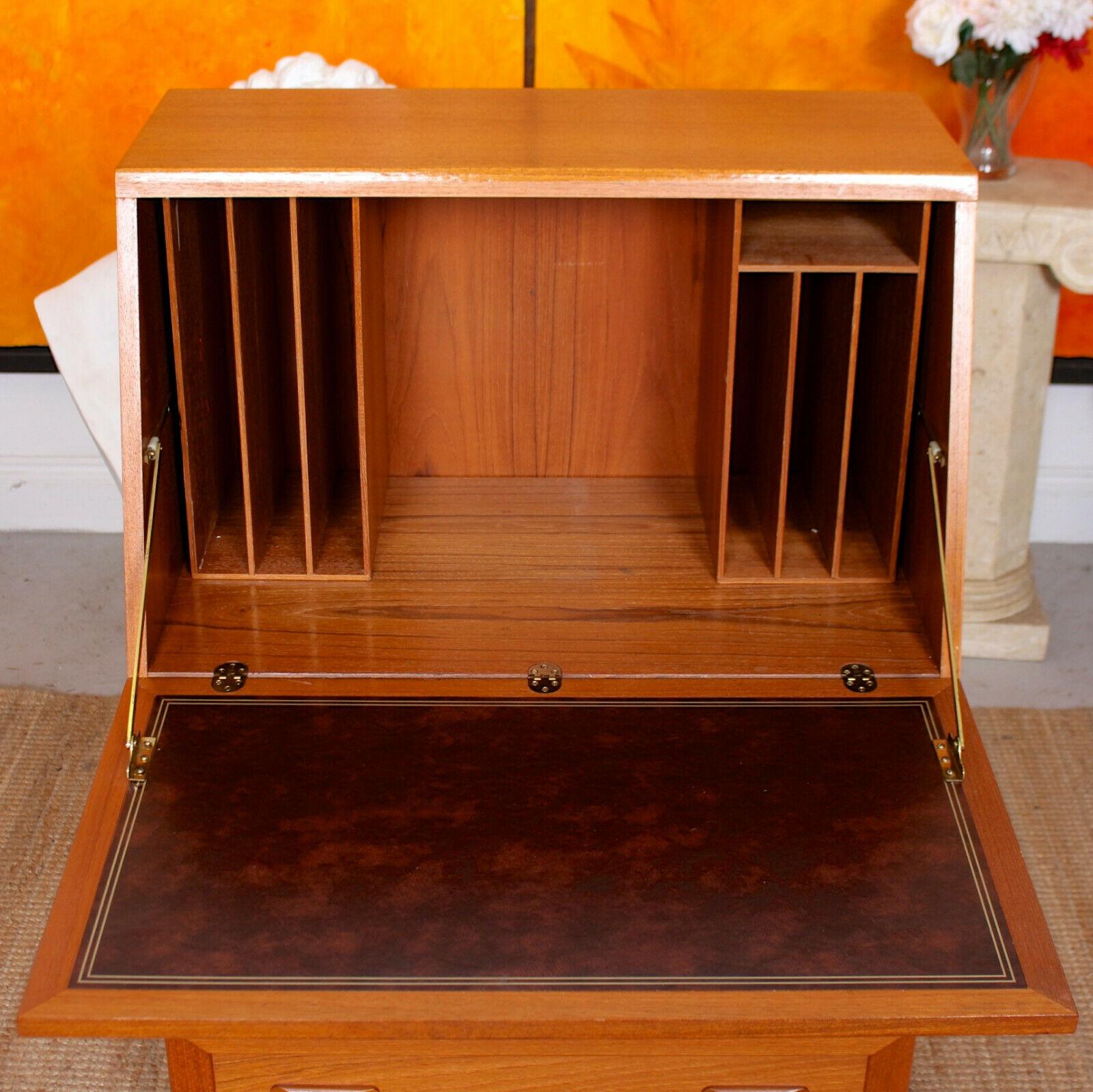 An impressive vintage teak writing bureau by G Plan.

The angled fall flap enclosed a fitted interior briefly comprising gilt tooled leather writing surface, cubby holes and shelving. Fitted three long graduated drawers below and raised on a
