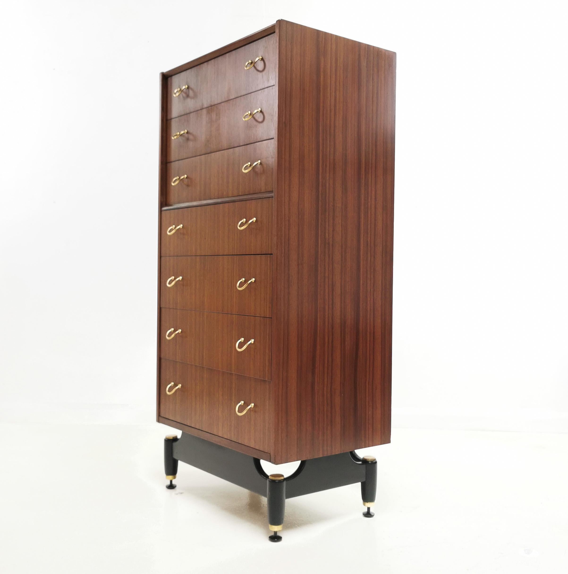 G Plan teak chest of drawers

G Plan teak tall boy chest of drawers from the 1960s. 

Graduated chest of drawers raised on an ebonized base with brass cup feet with original brass drawer pulls. 

Manufactured by Ernest Gomme, G Plan as part of