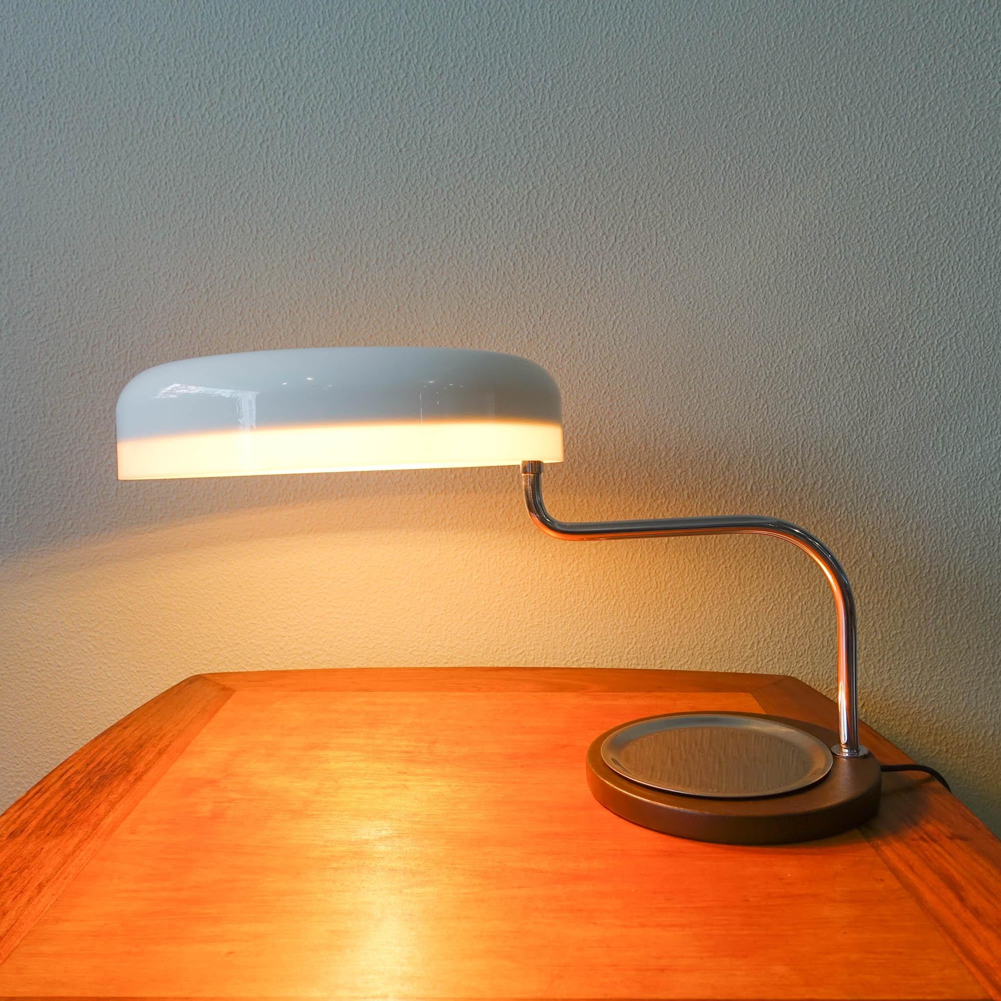 This lamp was designed by G.Scolari and produced by Metalarte in Spain, in 1973. The lamp has a chrome articulated neck, so the white lampshade can be spun out and extending to various angles (máx. 65 cm long). The base is covered in leather with a