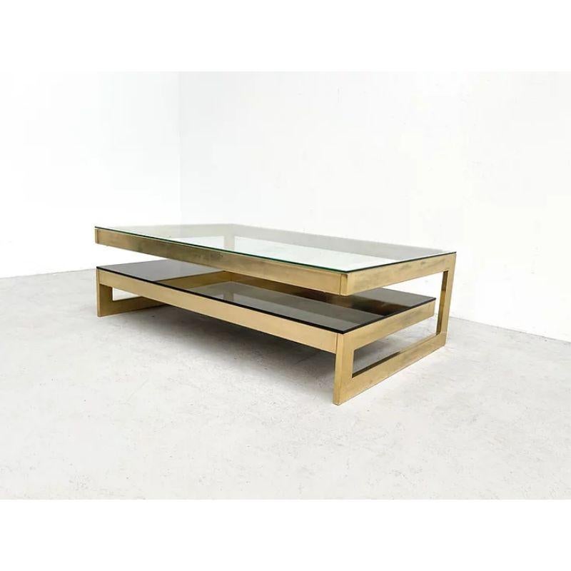 G Shaped Coffee Table in Glass with Brass Frame

Beautiful G-shape coffee table. The table was manufactered by the Belgian company Belgo Chrom. This is the brass version of the table. The bottom glass is a beautiful fumee glass. The table is in a