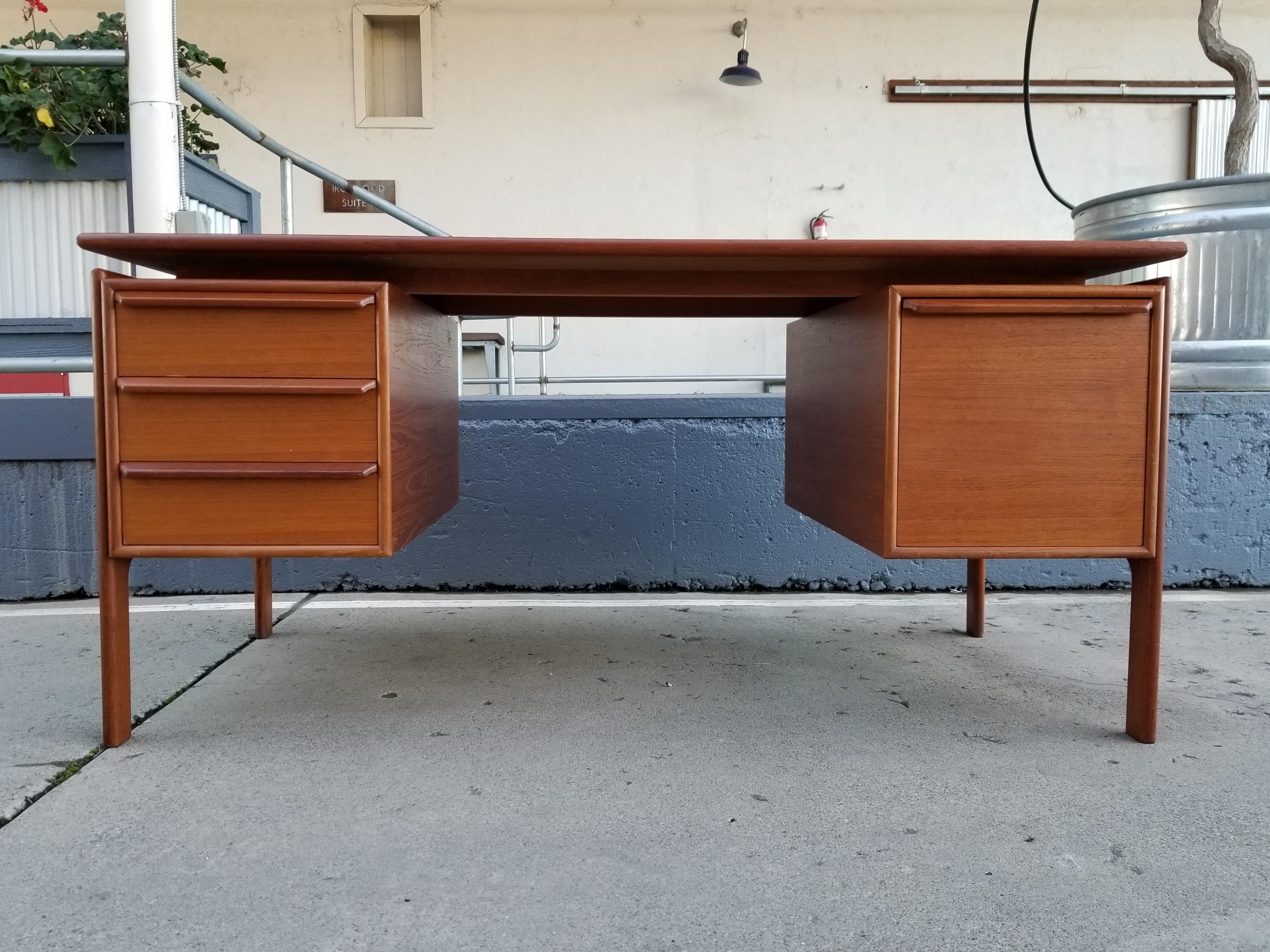 A teak Danish modern executive desk by GV Gasvig. Denmark, circa 1960s. Floating top and exoskeleton legs. Features 3 storage drawers and a file drawer. Very good original condition with original finish. Ample leg room. Knee opening measures 27