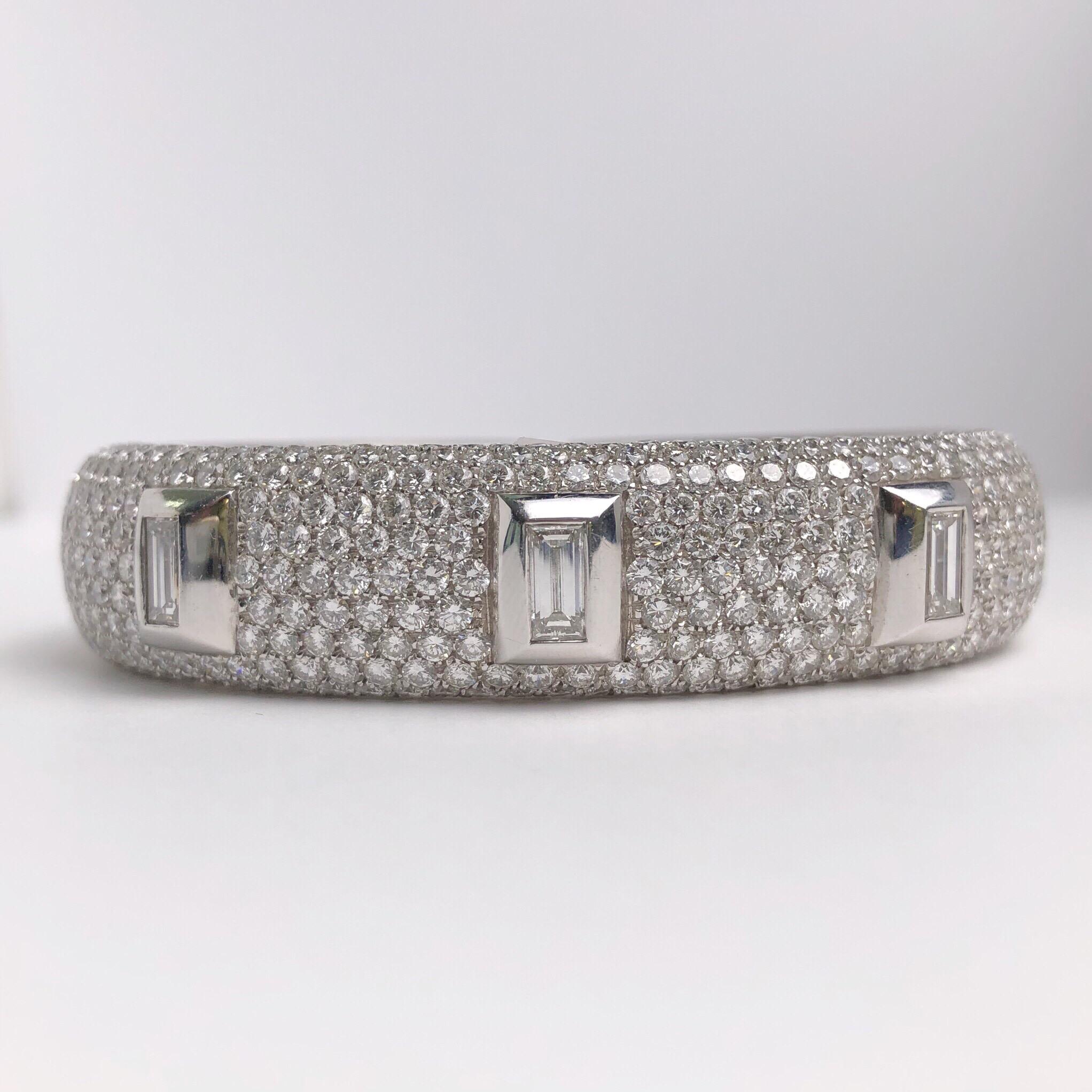 Made exclusively for Cellini by g.Verdi of Italy. This 14mm wide bangle is pave diamond set,along with three bezel set baguette shaped diamond solitaires. Total diamond weight 10.13 carats. The pave diamonds go halfway around. The other half is