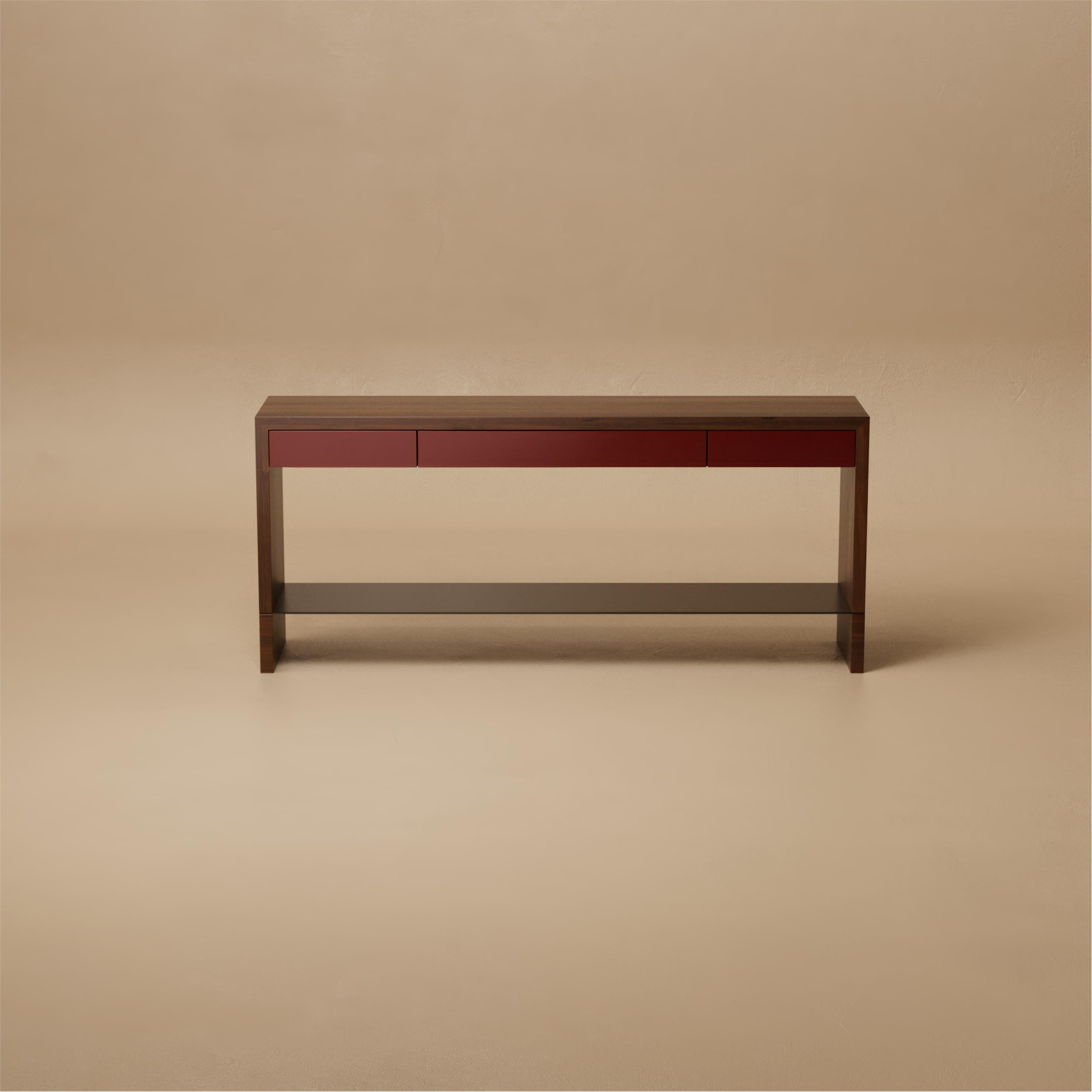The Grant Console Table is refined simplicity made architectural. Satin lacquer drawers glide beneath a walnut frame, while a slender metal shelf and leather inlaid drawers add layers of subtle detail. Each element, from the integrated pulls to the