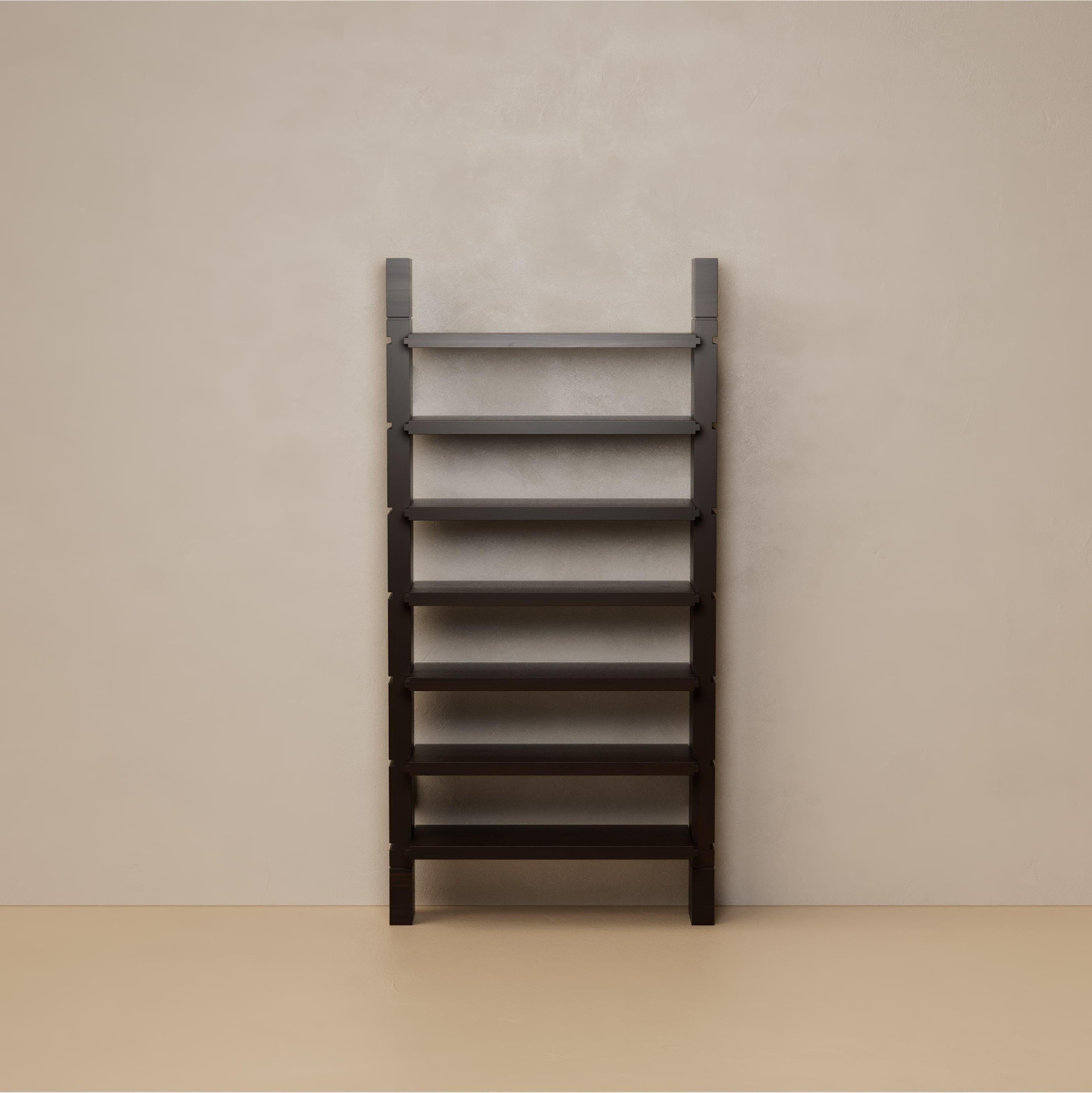 The Grant Bookshelf is architectural in spirit, conceived as a composition of floating walnut planes supported by slender steel standoffs. Its modular scale adapts to context, offering seven adjustable shelves that allow display and storage to
