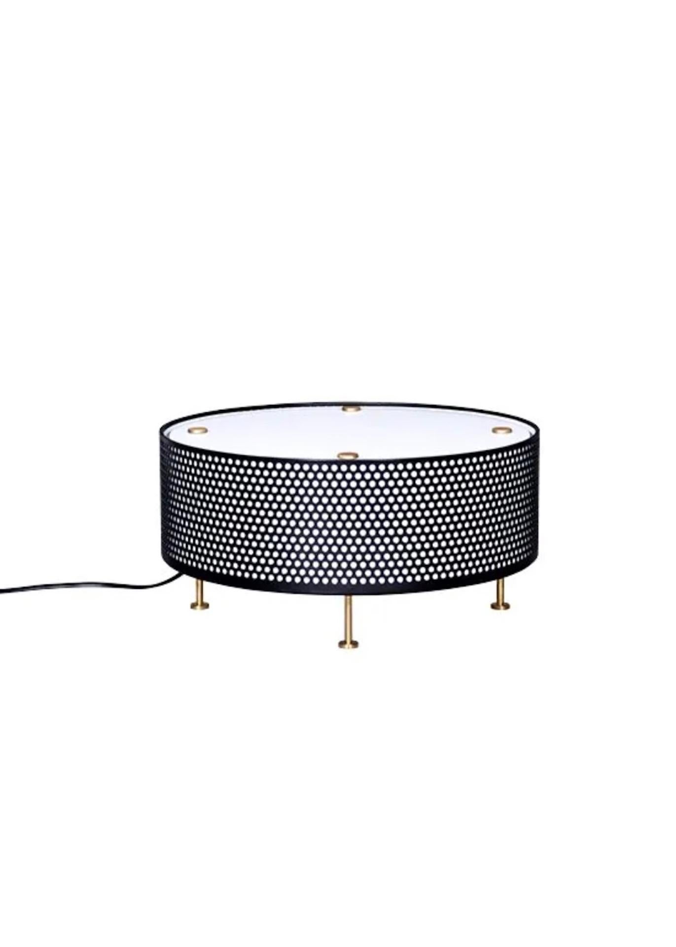 Diese Tischleuchte G50 verwendet einen Streuschirm, der eine mit einer Opalfolie ausgekleidete Lochblechtrommel verschließt, und wird von vier Messingfüßen getragen. Diese Leuchte gibt das Licht live an ihren Sockel zurück, durch Reflexion auf der