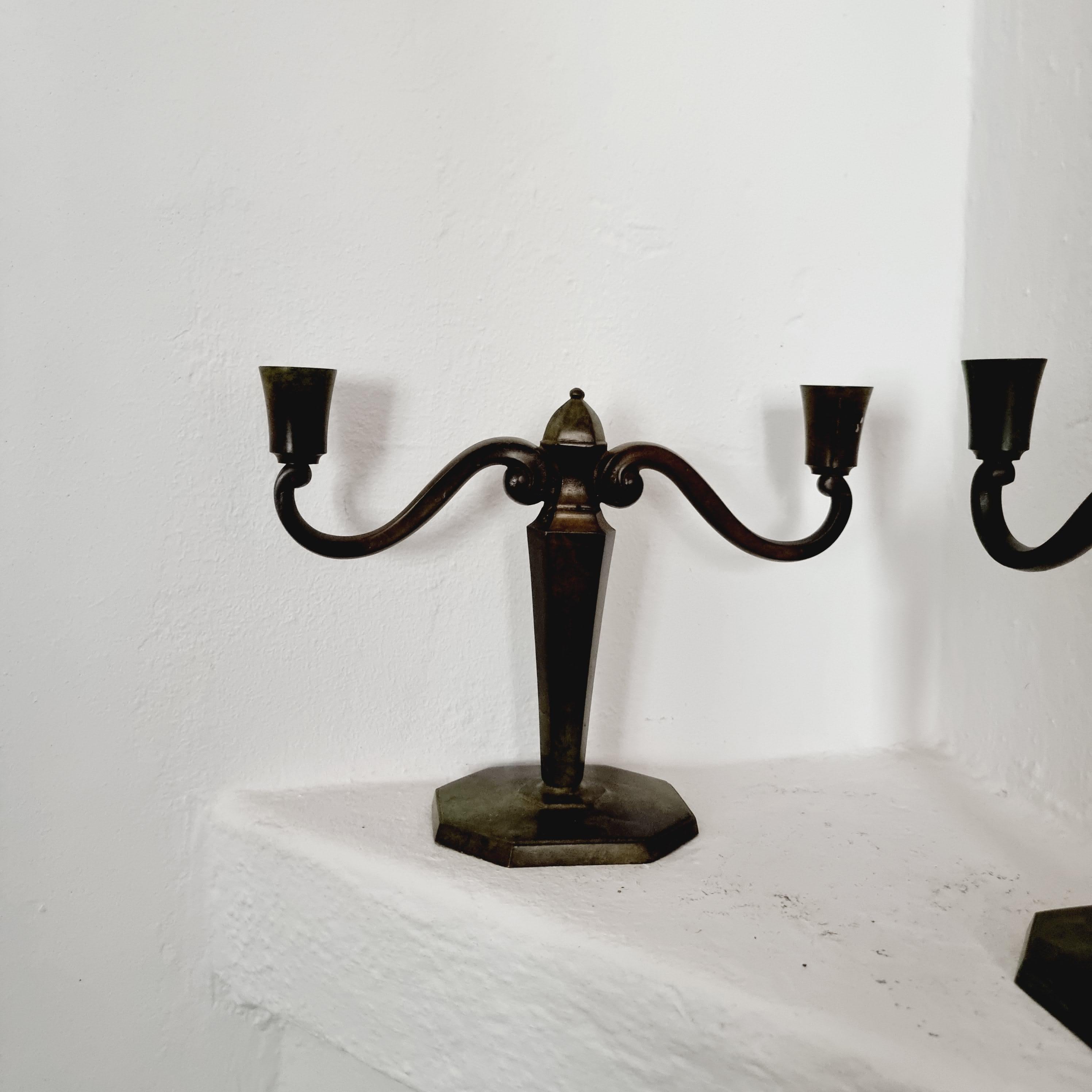 A elegant pair of solid bronze candelabras by Jacob Ängman for GAB / Guldaktiebolaget. With two candle holders each. Signed in bottom: GAB Brons.

