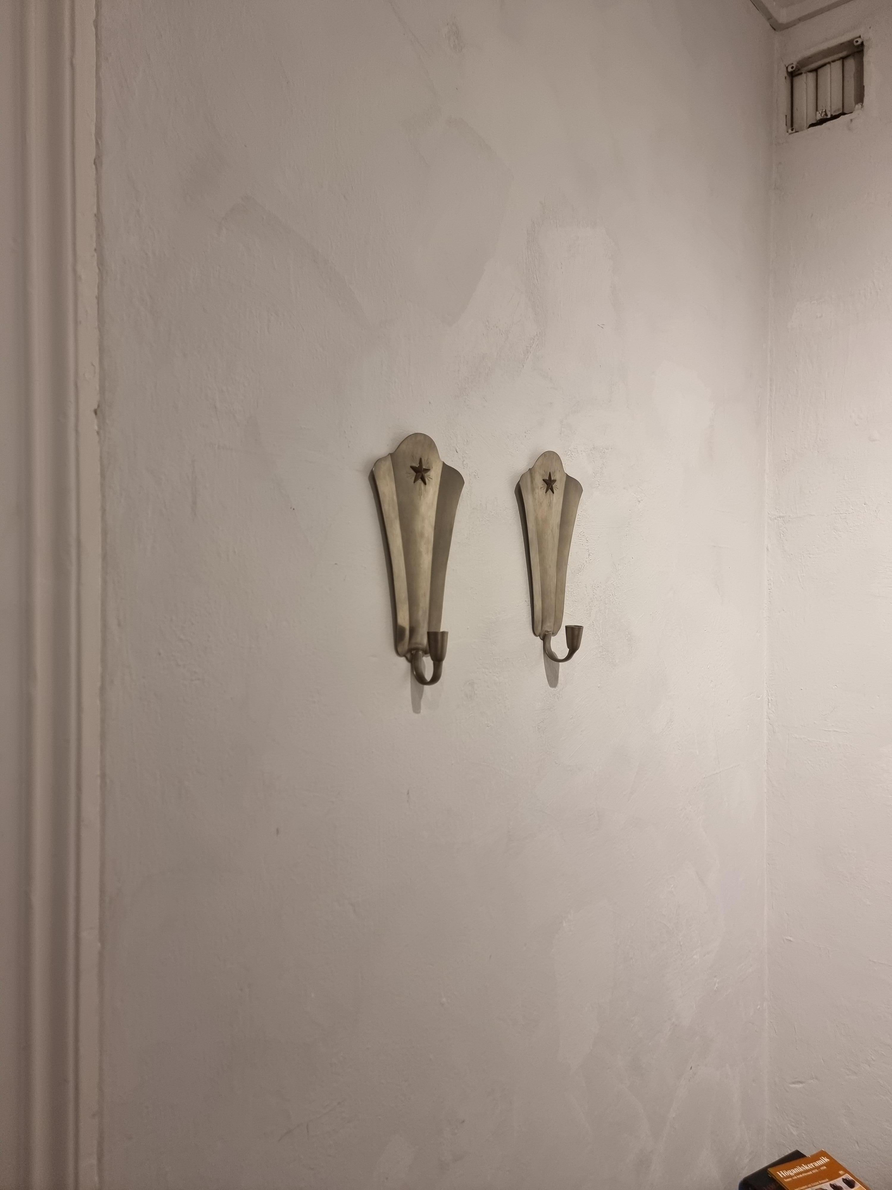 A pair of GAB/Guldaktiebolaget wall candle holders / sconces in pewter with star decor in brass.

Marked: GAB Tenn, O8/1940, Svensk bara. Stockholm hallmark.

In good condition, normal signs of age and wear.