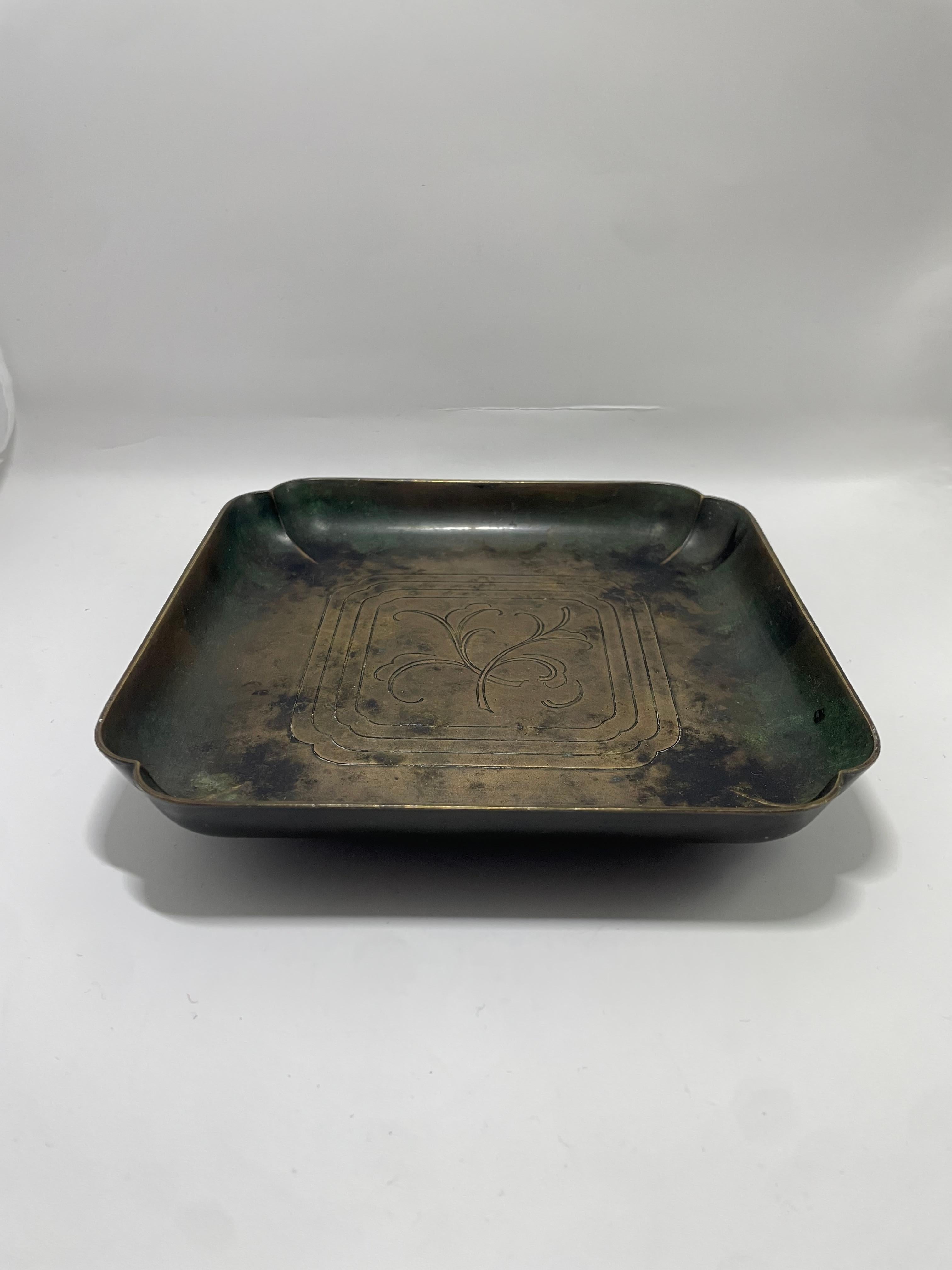 Llamativo cenicero cuadrado de bronce fabricado por GAB (Guldsmedsaktiebolaget) de Suecia, probablemente de mediados del siglo XXX. Esta pieza bellamente patinada presenta una forma cuadrada suavemente curvada con suaves hendiduras en las esquinas y