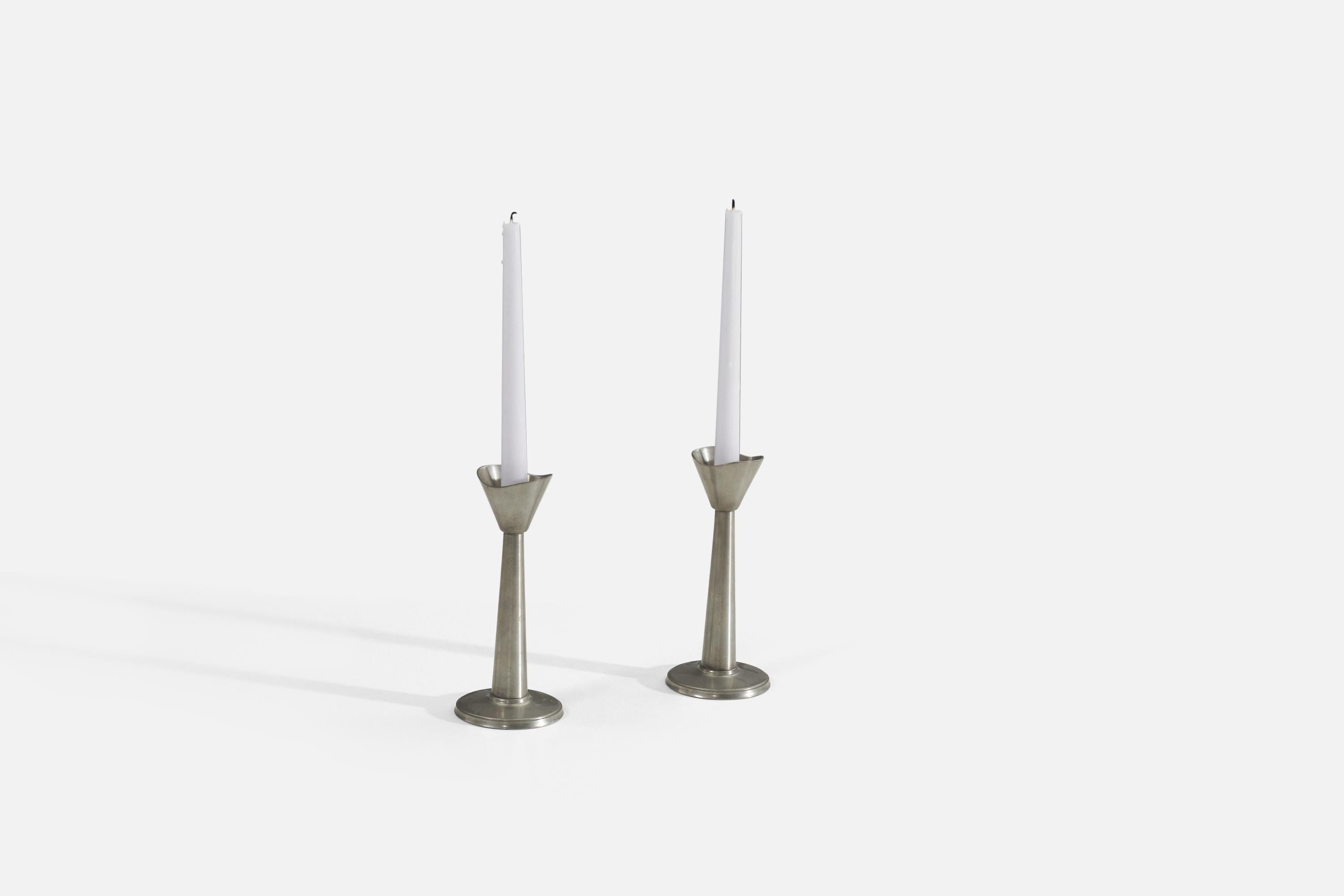 A pair of cast pewter candle holders / candle sticks produced by GAB, Sweden, 1930s. Maker's mark impressed to underside.