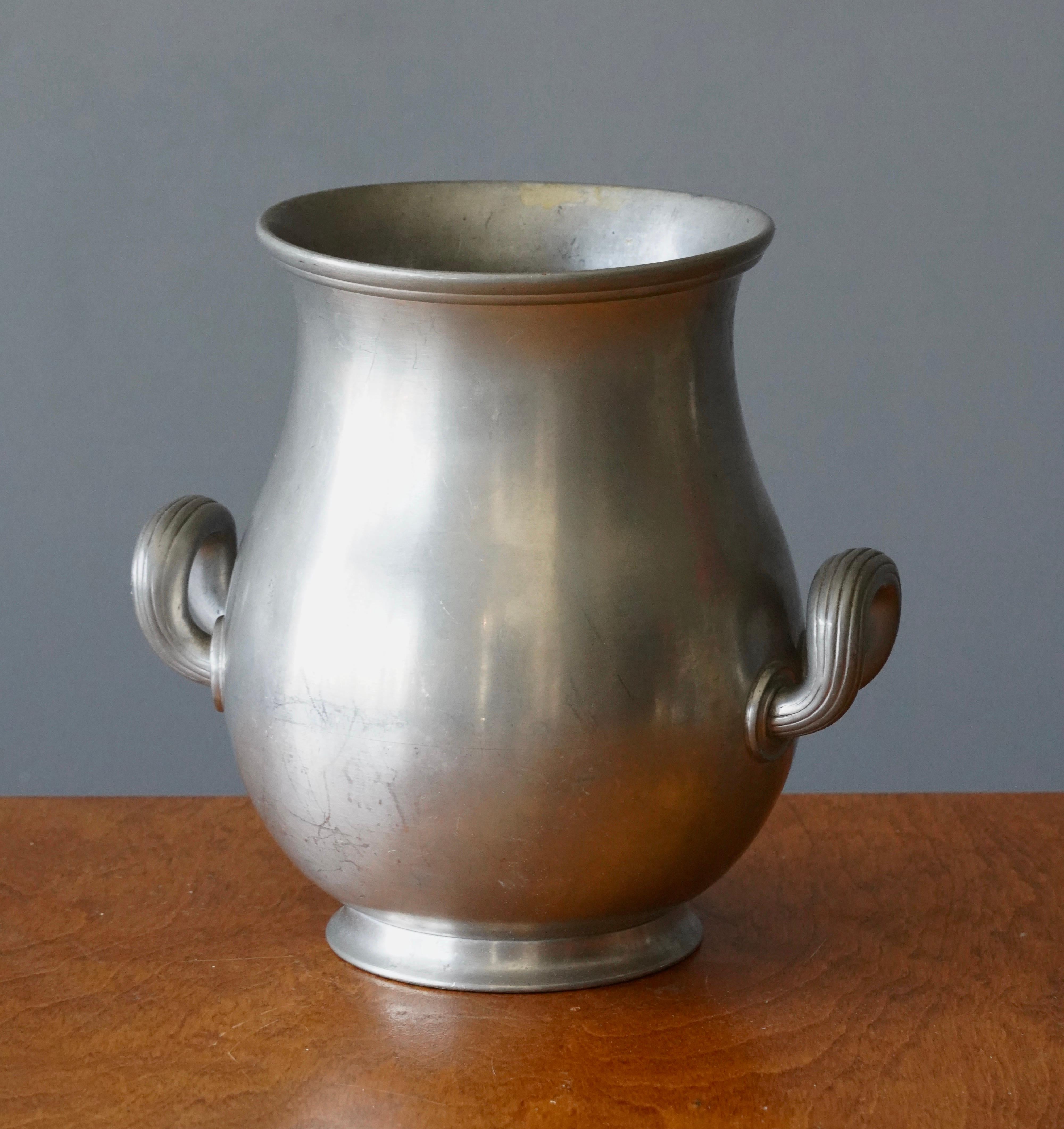 A vase or vessel, produced by GAB, stamped with makers mark, Sweden. In cast pewter. 

Other designers of the period include Josef Frank, Kaare Klint, Estrid Ericson, and Just Andersen.
  