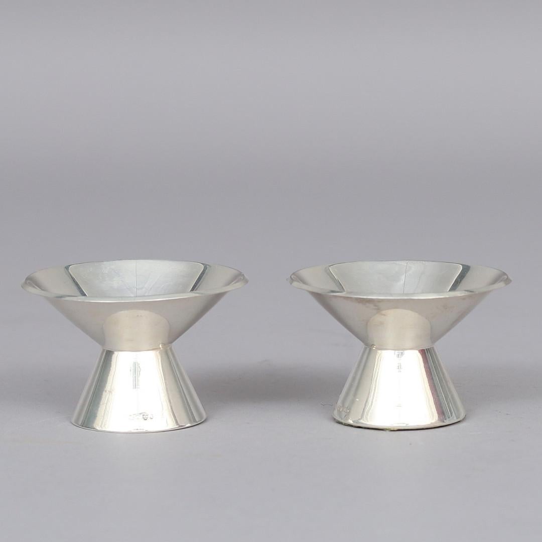 Un'impressionante coppia di portacandele in argento sterling svedese di metà secolo moderno, realizzati da Guldsmedsaktiebolaget (GAB) nel 1961. Questi pezzi scultorei sono caratterizzati da un caratteristico design conico svasato, elegante e