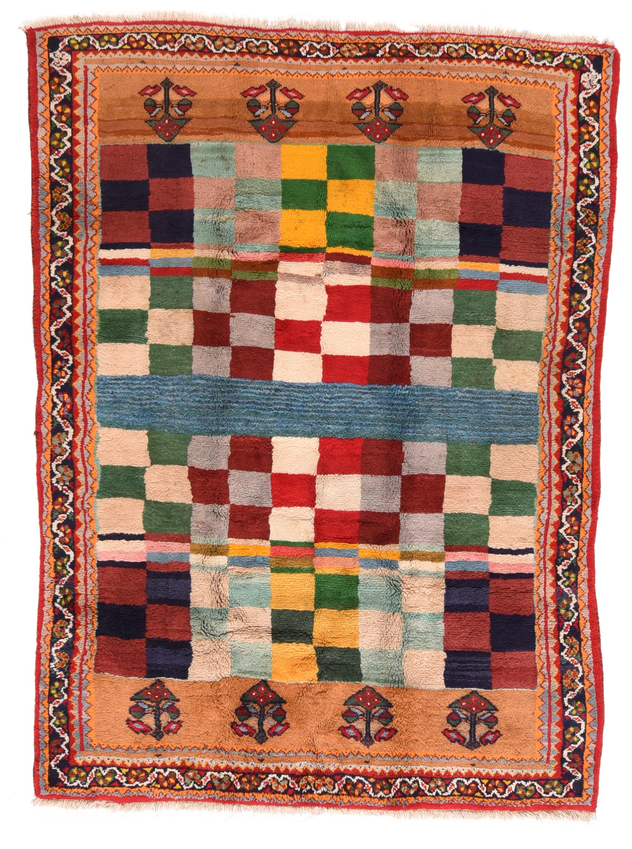 This nomadic all wool scatter shows a chessboard design of squares with a central cruciform array.Panels at each field end with four complete flowers each. Red, light blue, yellow, near black and eggshell detail tones. Ivory meander with reversing