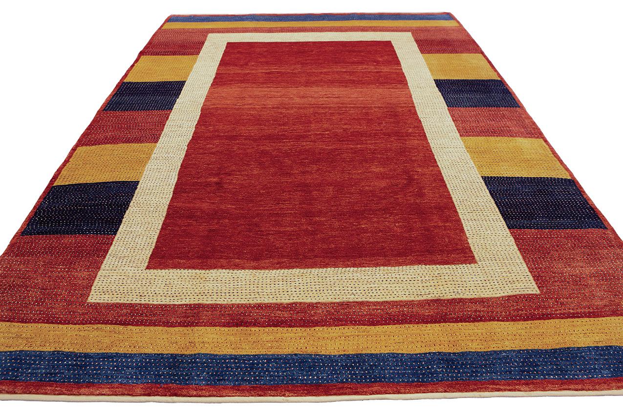 Il s'agit d'un tapis Gabbeh Royal au design moderne, fusion frappante de l'esthétique contemporaine et de l'artisanat traditionnel. Mesurant 283×193 cm, ce tapis présente un champ minimaliste orné d'une bordure colorée, créant un contraste captivant