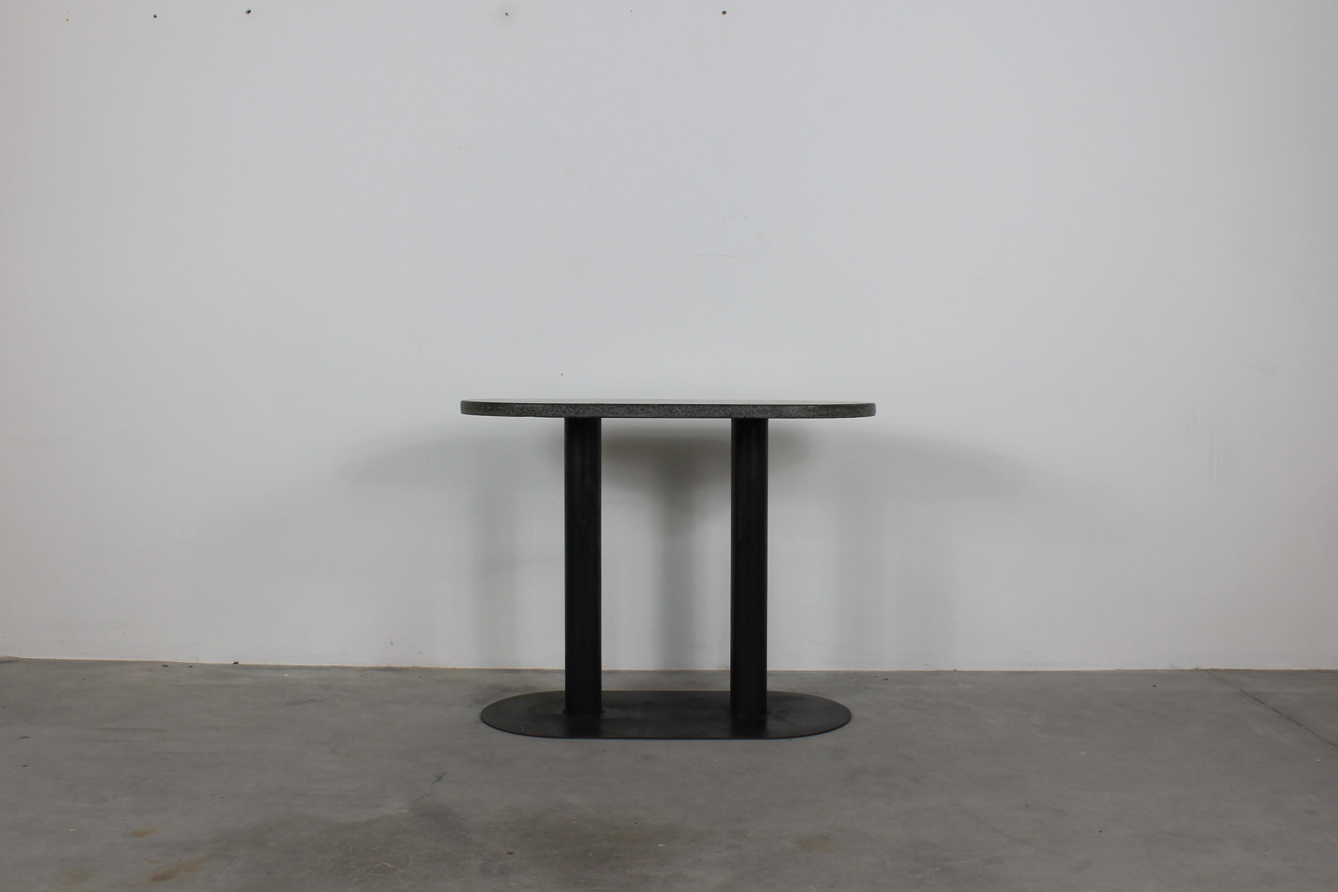 Console table with a base in black lacquered metal and an ovoidal table top in granite, originally designed by Aimaro Oreglia d'Isola and Roberto Gabetti for the residential center Talponia based in Ivrea and manufactured by Arbo during the