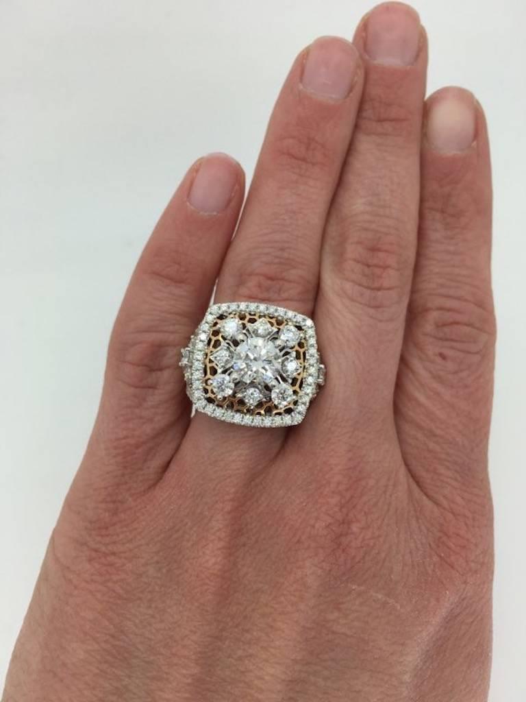 This intricate 18K white and rose gold ring features large 1.30CT Round Brilliant Cut Diamond with H-I color, SI2 clarity. It is accented by 96 additional Round Brilliant Cut Diamonds. The total diamond weight is approximately 3.10CTW. The ring is