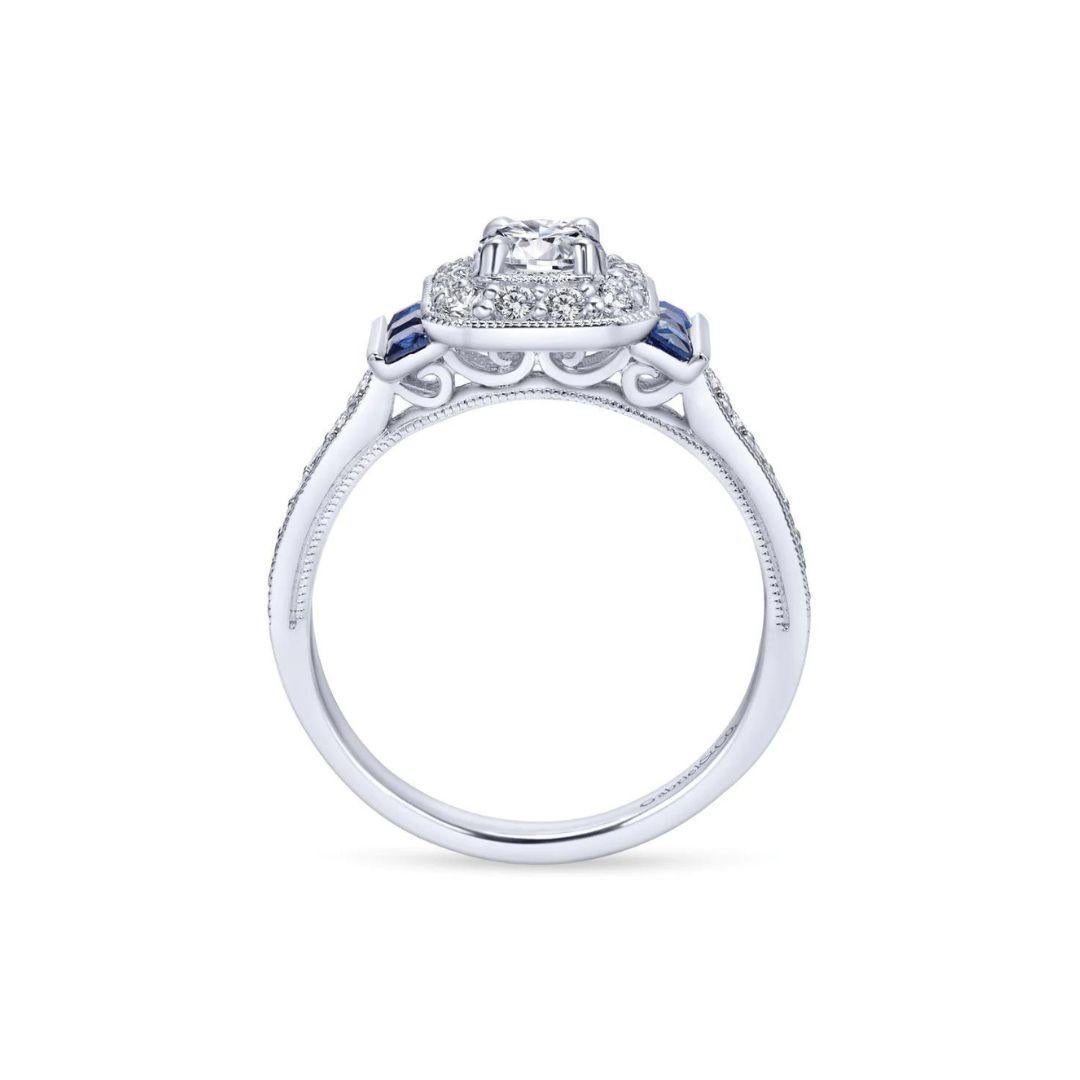 Ladies' 14k White Gold Diamond and Sapphire Engagement Ring﻿. Elegant vintage halo with milgrain finish, beautiful princess cut blue sapphires on the sides, and diamond pave on the ring's shank give this one of a kind ring a romantic vintage appeal.