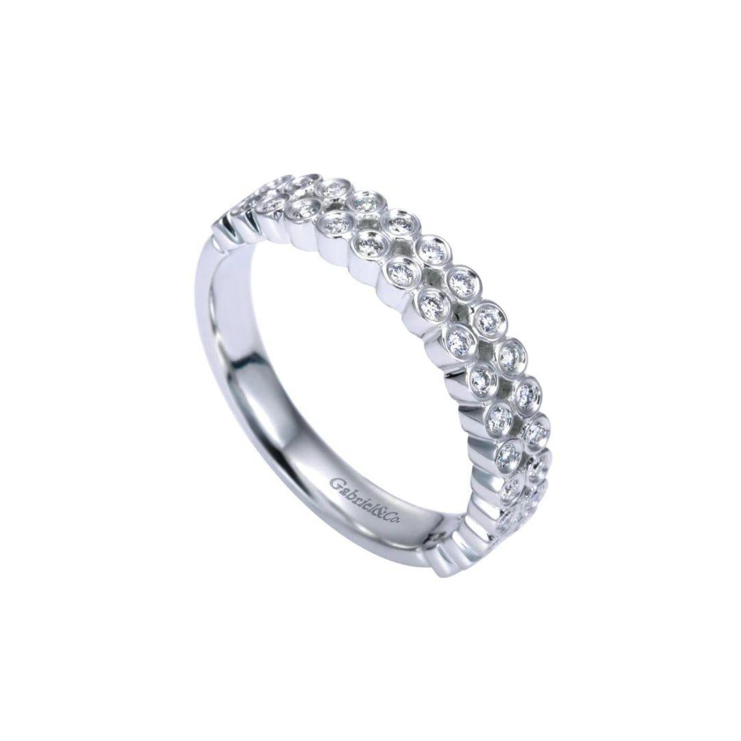 Two rows of bezel set diamonds play on a classic theme with a modern twist. Band contains 0.23 ctw of fine white round diamonds, H color, SI clarity set in 14k white gold. Band is suitable as a fashion ring, anniversary ring, a wedding band or a