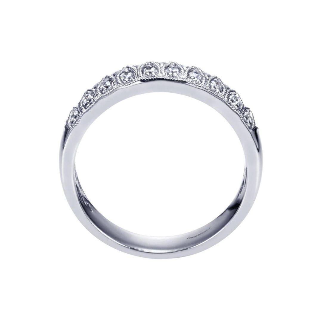 Two rows of alternating diamonds and curvy milgrain lines create a look that evokes a royal sentiment. Band contains 0.30 ctw of fine white round diamonds, H color, SI clarity, set in 14k white gold. Band is suitable as a fashion ring, anniversary