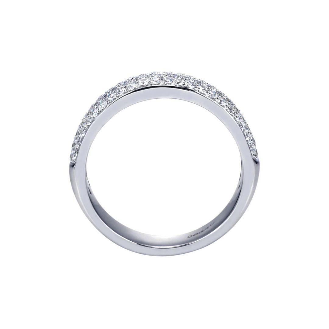 Three rows of pave set diamonds in a delicately domed band shine with a three dimensional luster. Band contains 0.50 ctw of fine white round diamonds, H color, SI clarity. Band is suitable as a fashion ring, anniversary ring, a wedding band or a