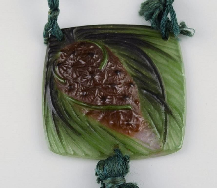 GABRIEL ARGY-ROUSSEAU (1885-1963), Frankreich. Pomme de pin Anhänger / Halskette aus Kunstglas. 
Pâte-de-verre-Technik. 1920s.
Maße: 5.7 x 5,7 cm.
In ausgezeichnetem Zustand.
Unterschrieben.
Inklusive Originalverpackung.